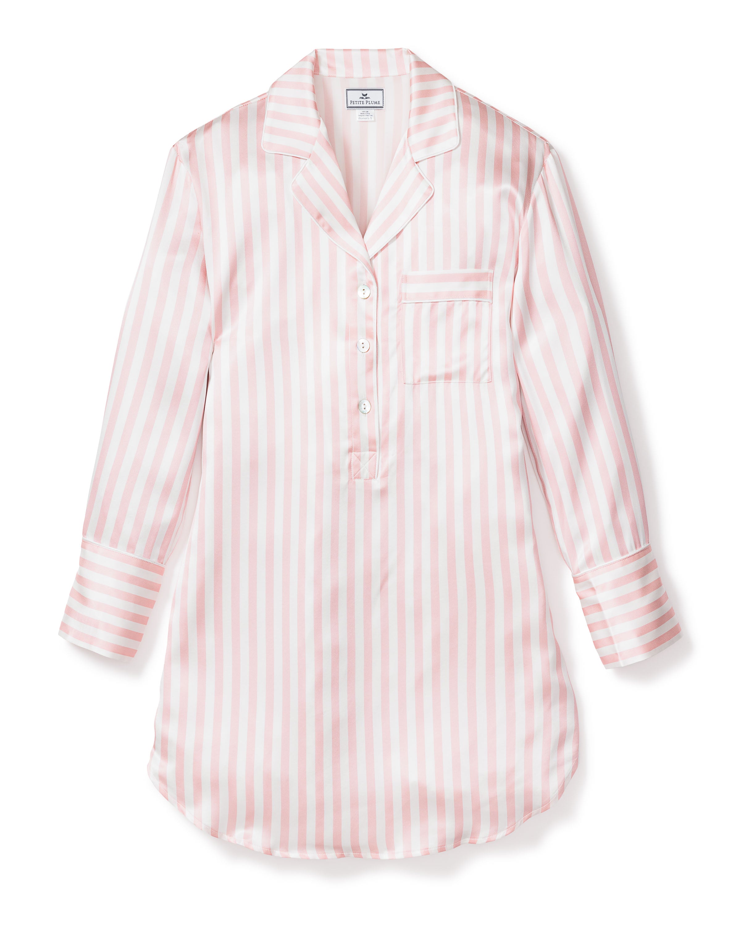 The Womens Silk Nightshirt in Pink Stripe by Petite Plume is a long-sleeve, button-up blouse made of luxurious Mulberry silk. It has pink and white stripes, a left-side pocket, a notched collar, four buttons, and a rounded hem with a slight shine for added elegance.