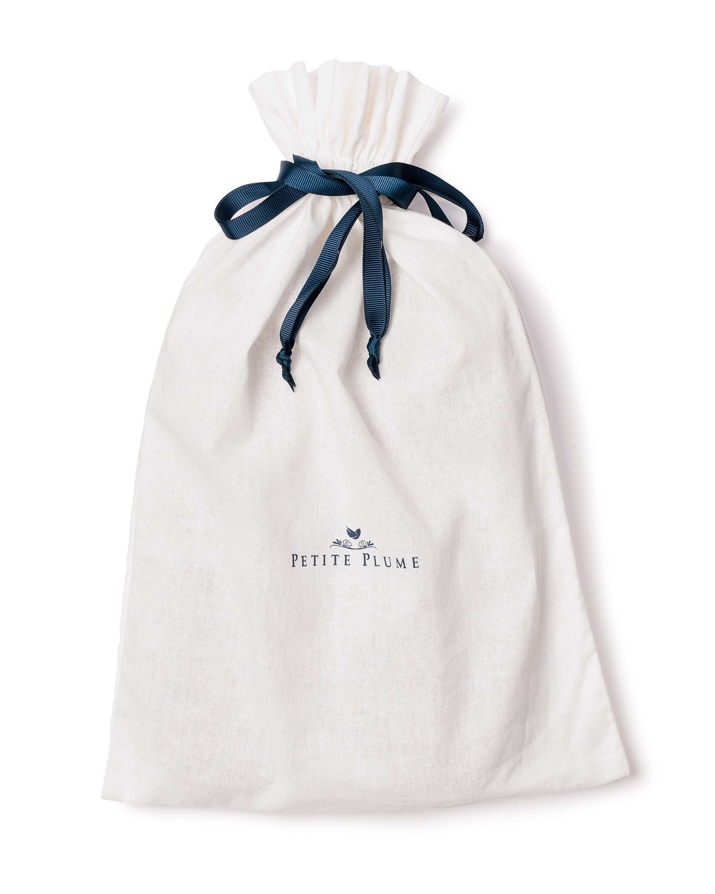 The Petite Plume Womens Cashmere Slippers in Beige are a cozy fit complement, coming in a white drawstring bag with a navy ribbon and featuring the brands logo and a small bird graphic.