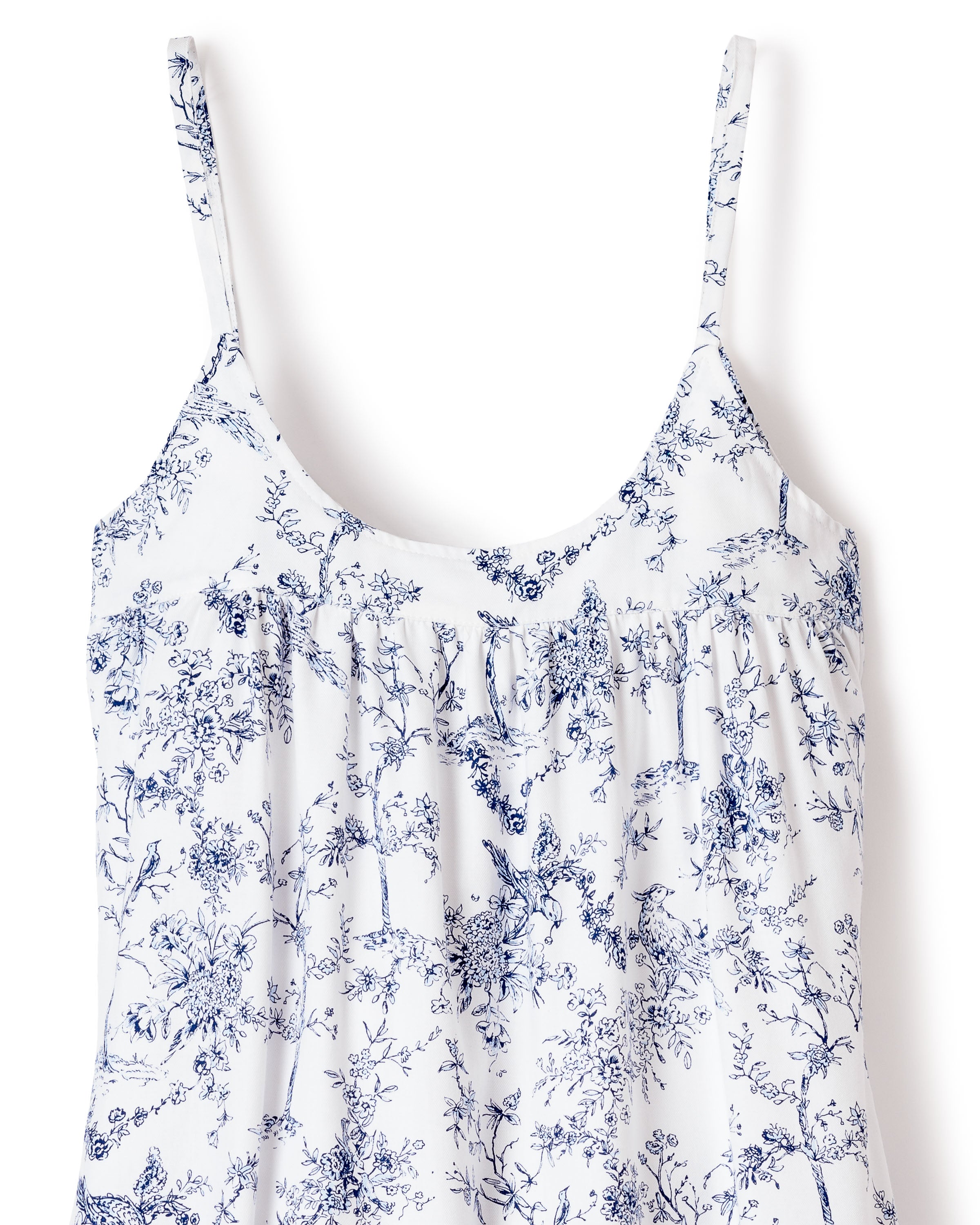 This elegant Womens Twill Chloé Nightgown by Petite Plume features a vintage-inspired white design with thin straps and a blue floral pattern, such as trees and flowers. Its slightly gathered bust adds allure, capturing the charm of a timeless toile print.