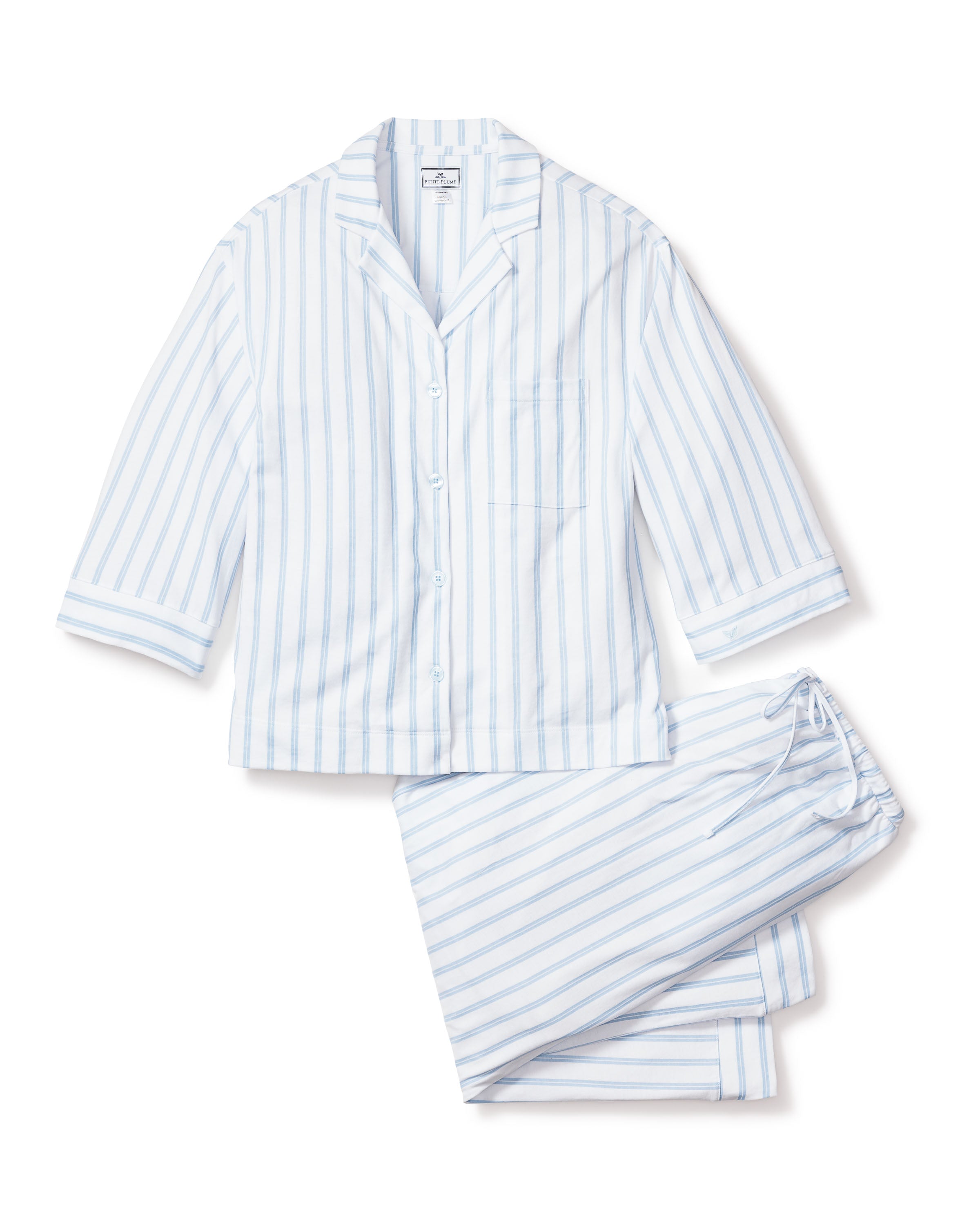 The Olivia Wide Leg Pima Pajama Set in Periwinkle Stripe by Petite Plume features a button-up top with a chest pocket and drawstring pants. Crafted from breathable fabric, its thin blue stripes on white offer a classic, luxurious look for restful nights.