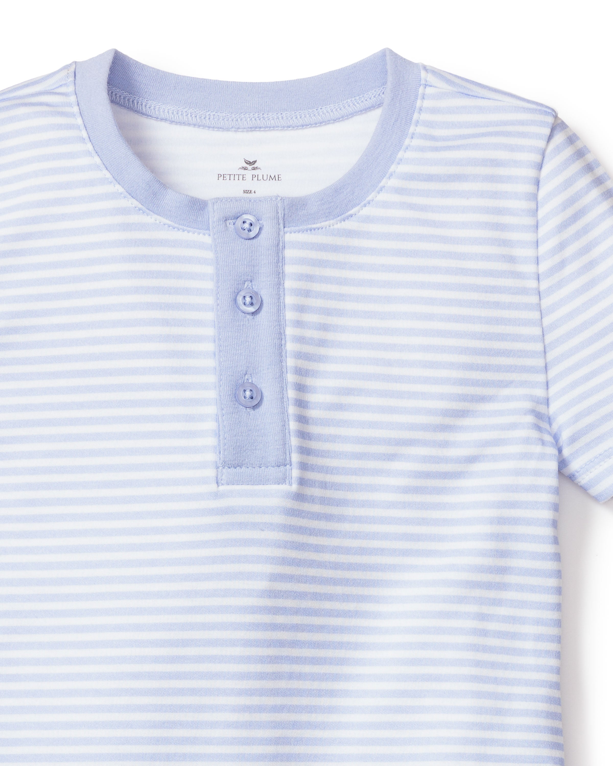 A close-up of Petite Plumes Kids Pima Snug Fit Pajama Short Set in blue stripes, featuring a round neckline and three buttons on a short placket. Crafted from soft, comfortable Pima cotton for the perfect blend of style and luxury.