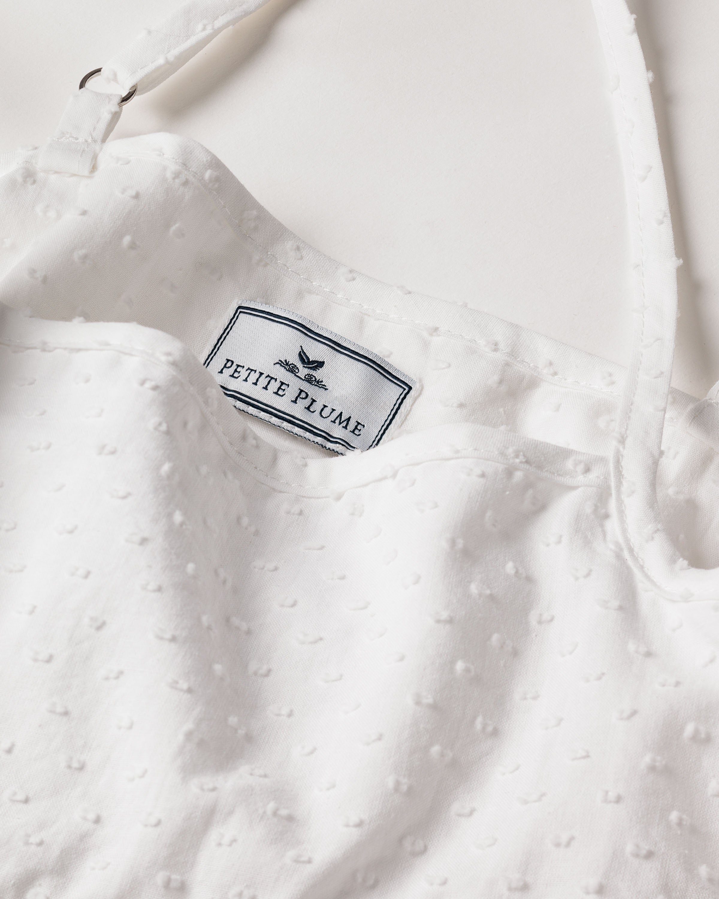 The Girls Swiss Dots Serene Day Dress in White by Petite Plume is a luxury sleepwear garment with a soft, lightweight feel, featuring a subtle Cotton Swiss Dot texture and a top strap.