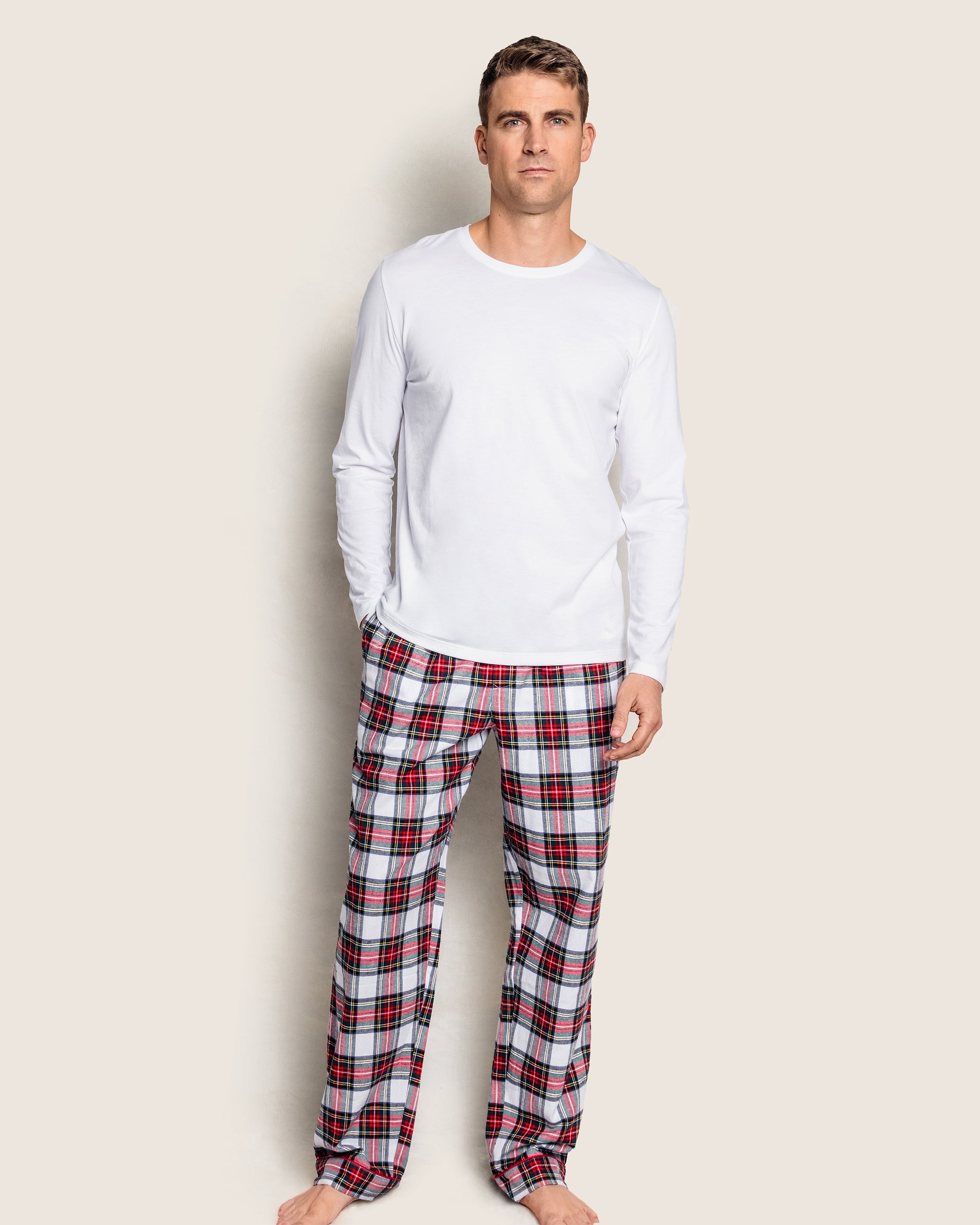 A person stands barefoot in a plain white shirt and Petite Plumes Mens Brushed Cotton Pants in Balmoral Tartan, made from premium cotton.