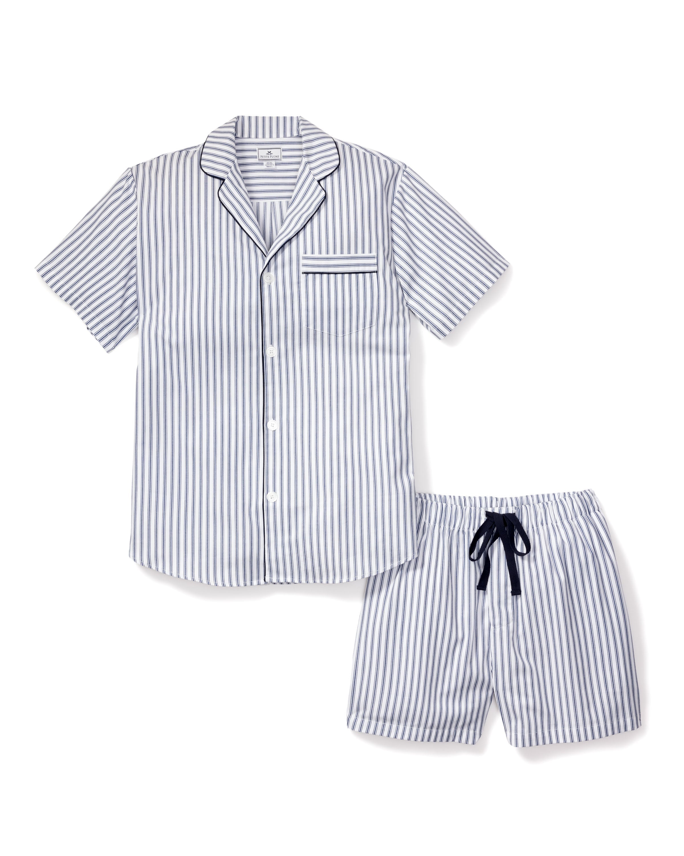 Indulge in the luxurious Mens Twill Pajama Short Set in Navy French Ticking by Petite Plume, featuring a short-sleeved button-up shirt with a pocket and matching shorts. Made from premium cotton, it showcases elegant blue and white stripes with a chic black drawstring on the shorts.