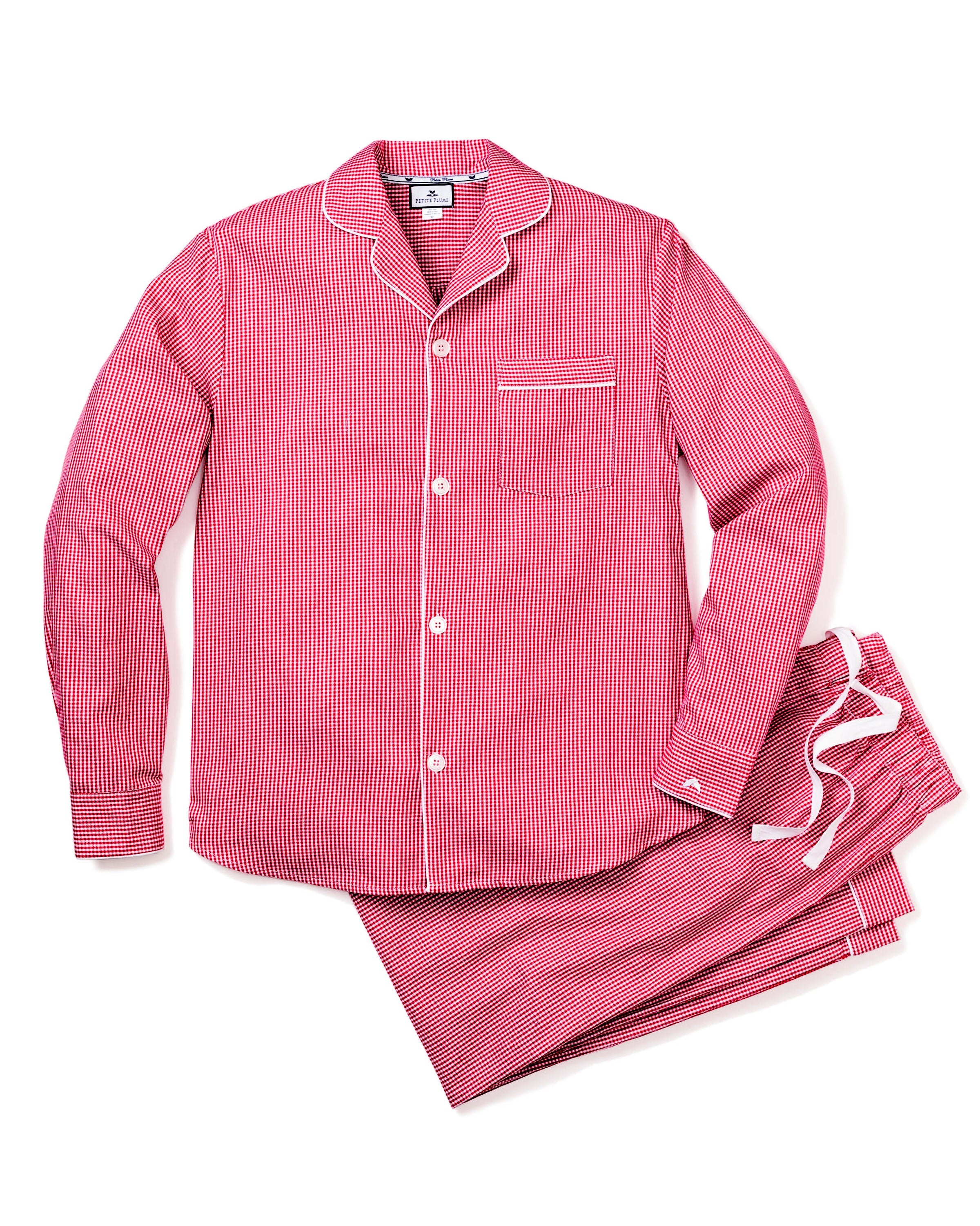 The Petite Plume Mens Flannel Pajama Set in Red Mini Gingham exudes luxurious charm with a long-sleeve button-up top featuring a chest pocket and matching pants with a white drawstring, neatly laid out against a plain white background.