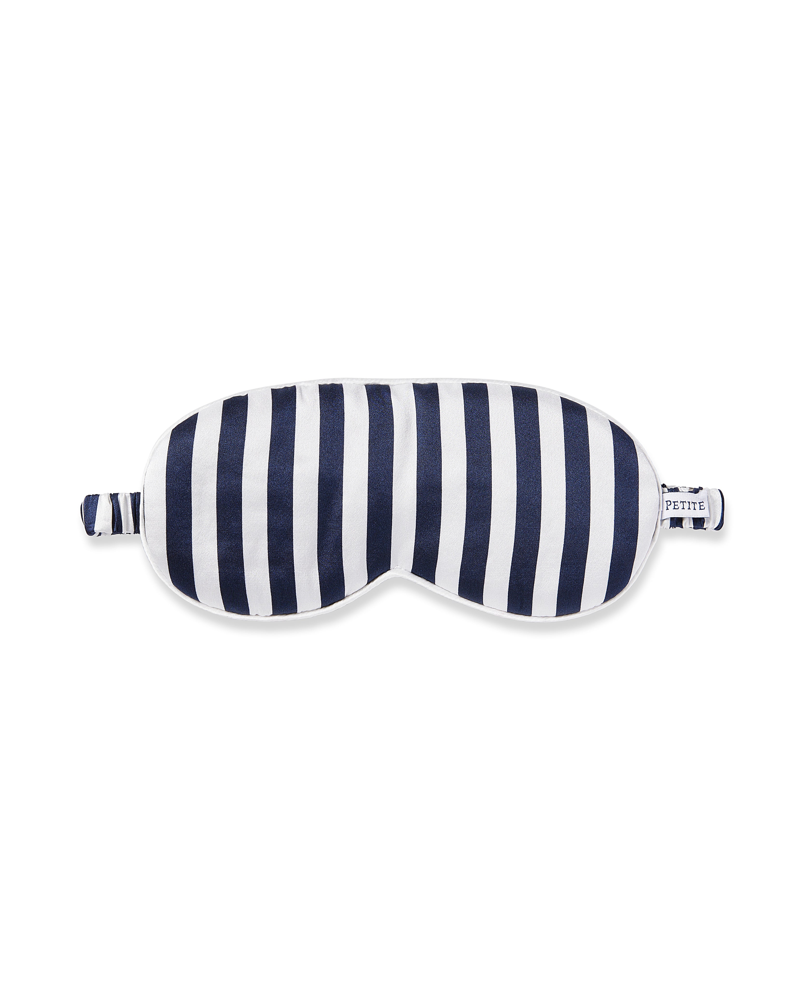 The Petite Plume Adults Silk Sleep Mask in Navy Bengal Stripe features smooth silk with a simple yet elegant design and small side loops for securing.