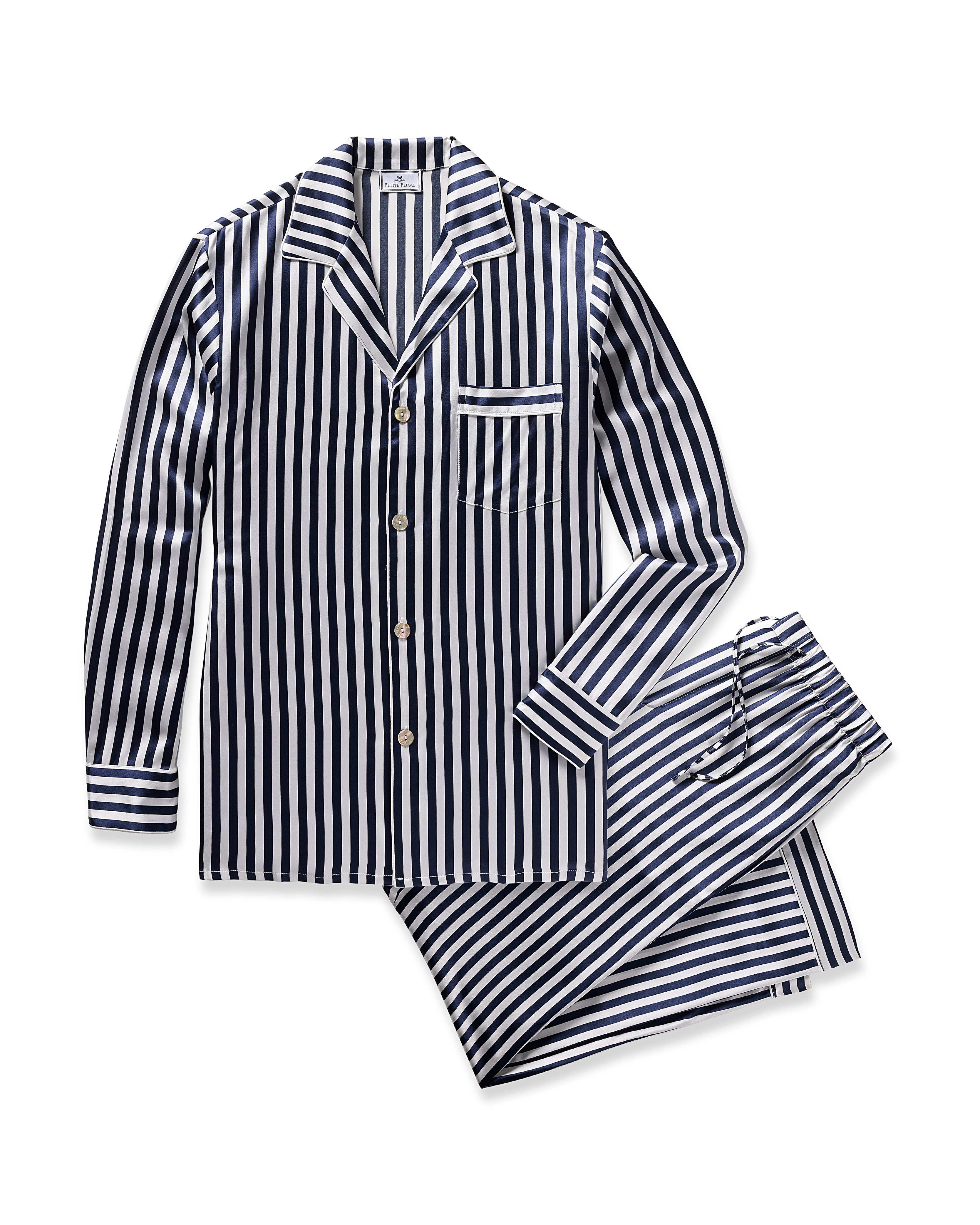 The Mens Silk Pajama Set in Navy Bengal Stripe by Petite Plume is a luxurious sleepwear, crafted from soft mulberry silk with black and white vertical stripes. It features a button-up top with long sleeves and chest pocket, and matching pants with an elastic waistband.