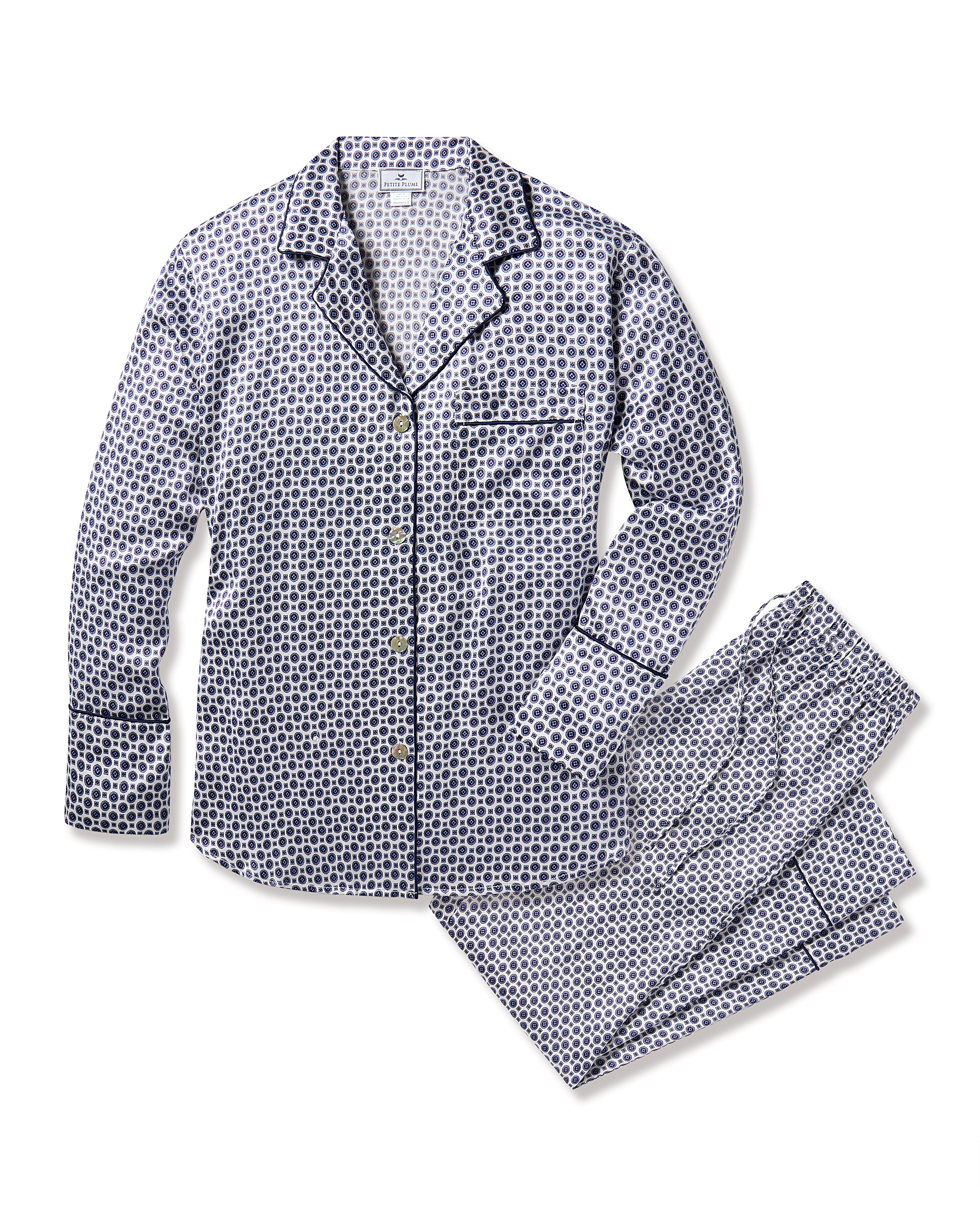 The Womens Silk Pajama Set by Petite Plume features a geometric navy foulard pattern. Made from hypoallergenic silk, it includes a long-sleeved button-up top with a chest pocket and matching pants with an elastic waistband, both stylishly detailed with black piping for elegance.