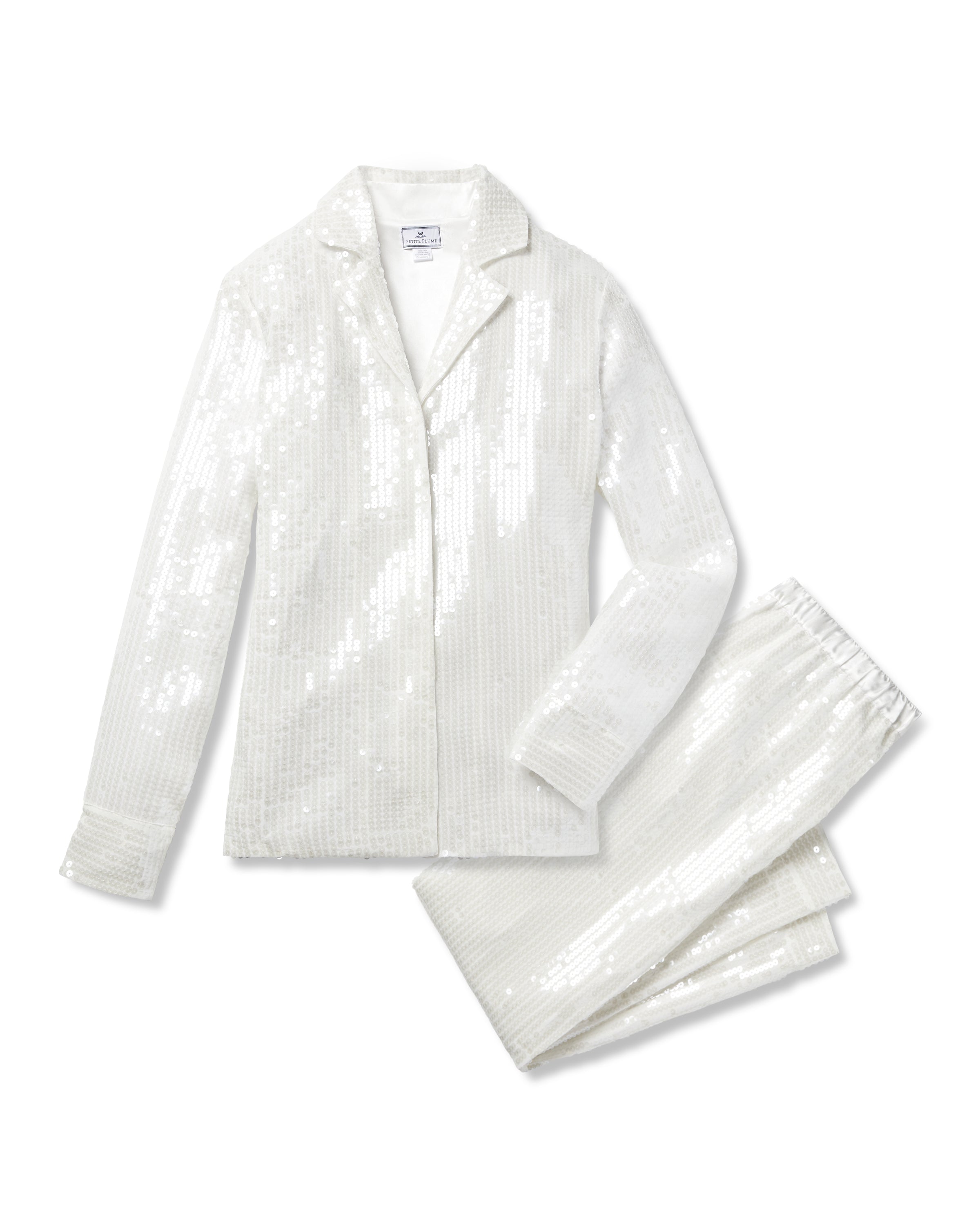 The Womens Sequin Pajama Set in White by Petite Plume boasts a classic pajama design with a long-sleeved button-up top and matching pants, adorned with shimmering white sequins for a glamorous effect.