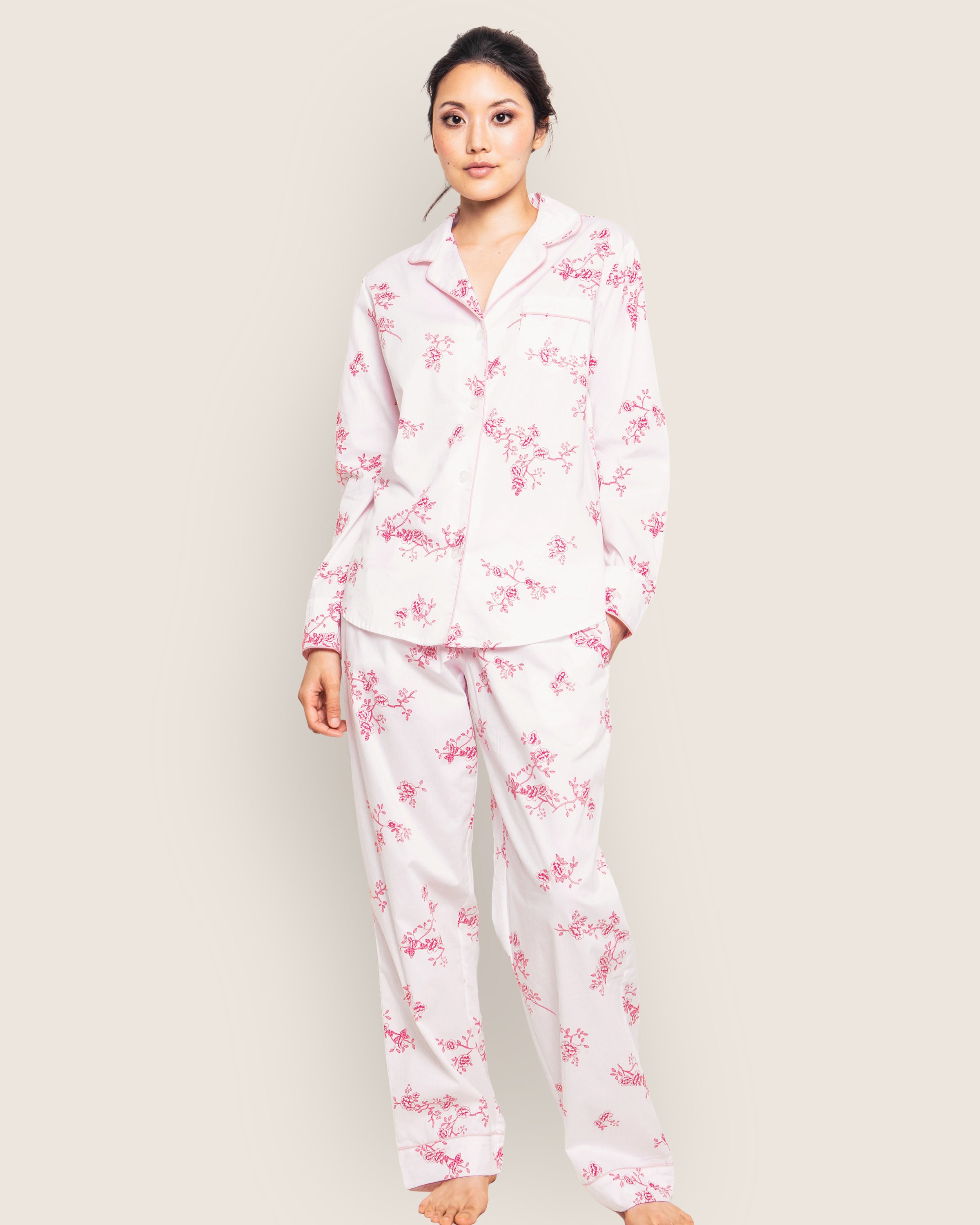 A person wears Petite Plumes Womens Twill Pajama Set in English Rose Floral, barefoot against a plain light background. Made from the finest quality cotton, the collared button-up top and loose-fitting pants are both comfortable and elegant.