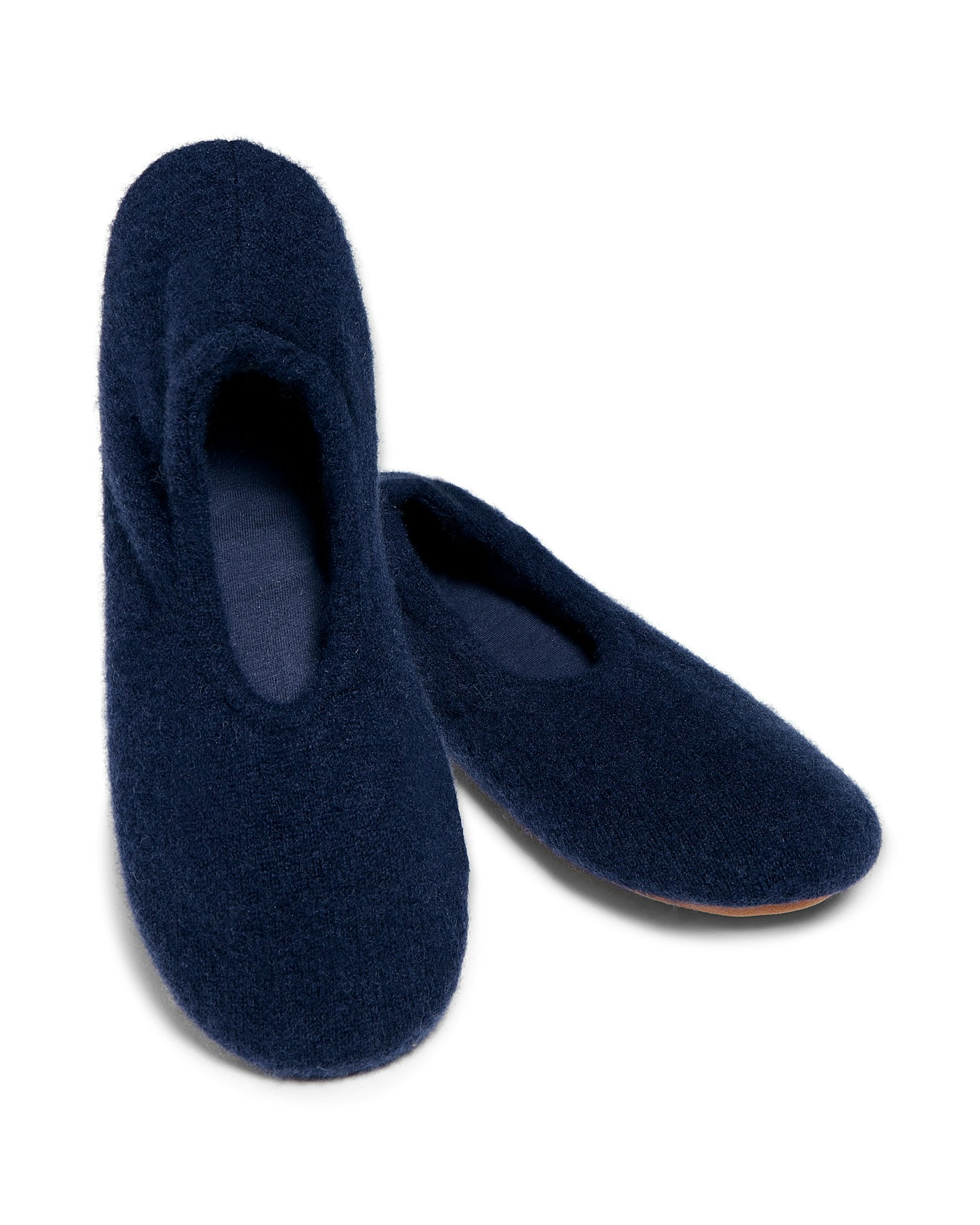 Petite Plumes Womens Cashmere Slippers in Navy are cozy and elegant with a simple rounded toe design, crafted from Grade A pure cashmere. They rest stylishly side by side on a plain white background.