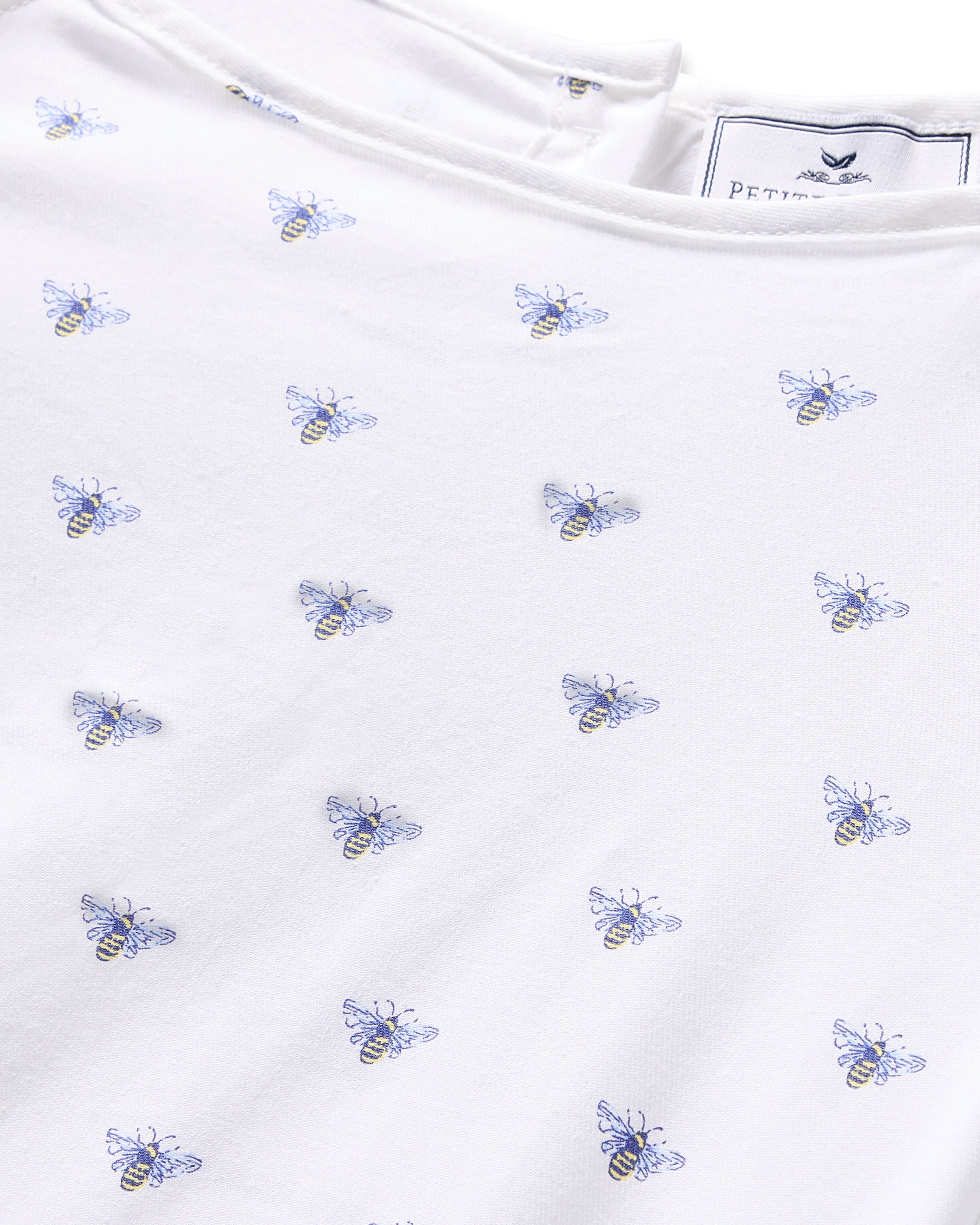 The Girls Twill Amelie Nightgown by Petite Plume features a white cotton design with embroidered blue and yellow bees evenly distributed, complete with a flame retardant label at the top.