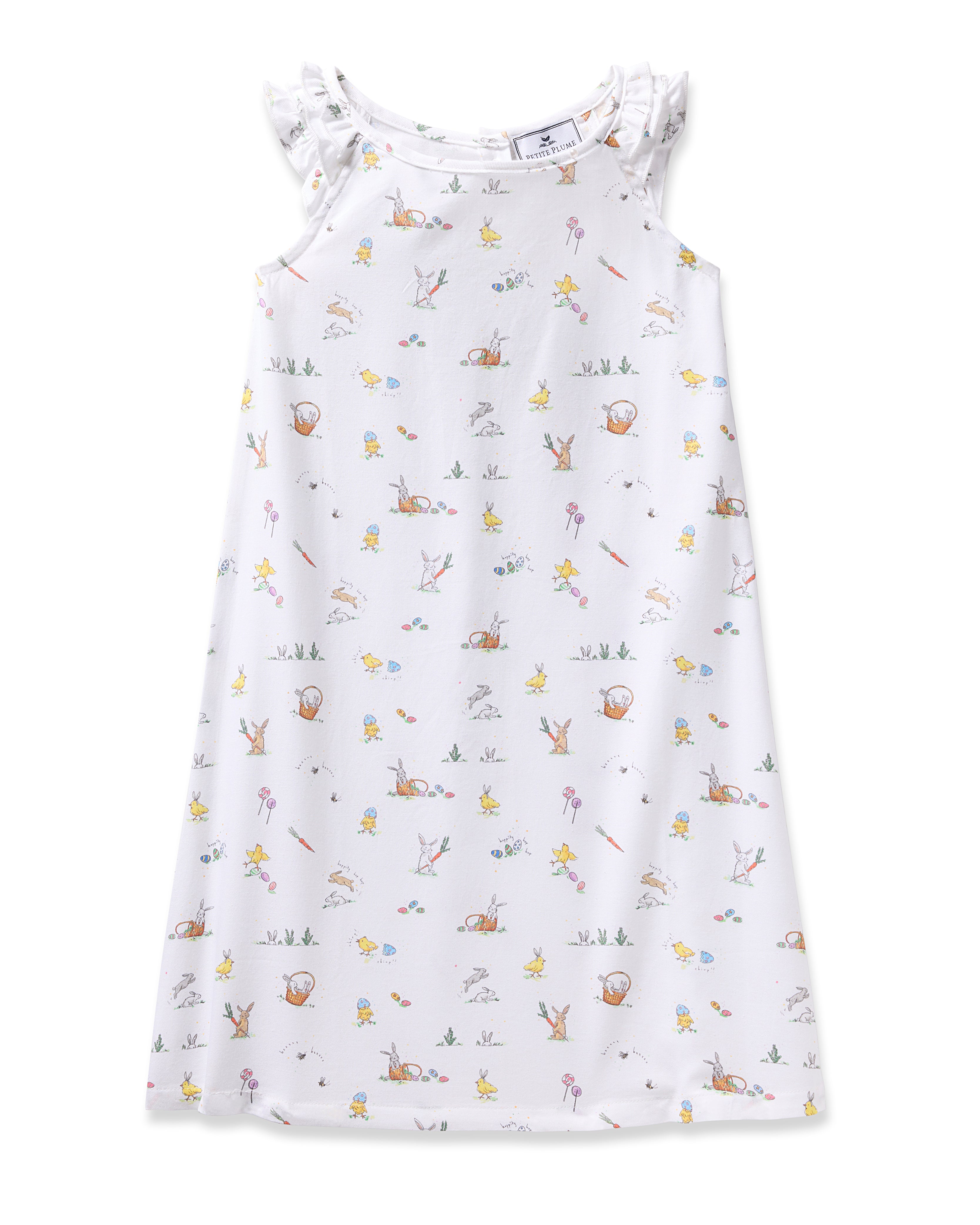 The Girls Twill Amelie Nightgown in Easter Frolic by Petite Plume is a sleeveless white dress with ruffled shoulders and features whimsical rabbits, ducks, and flowers. Its soft pastel colors give a charming look, ideal for lovers of luxurious sleepwear with a playful twist.