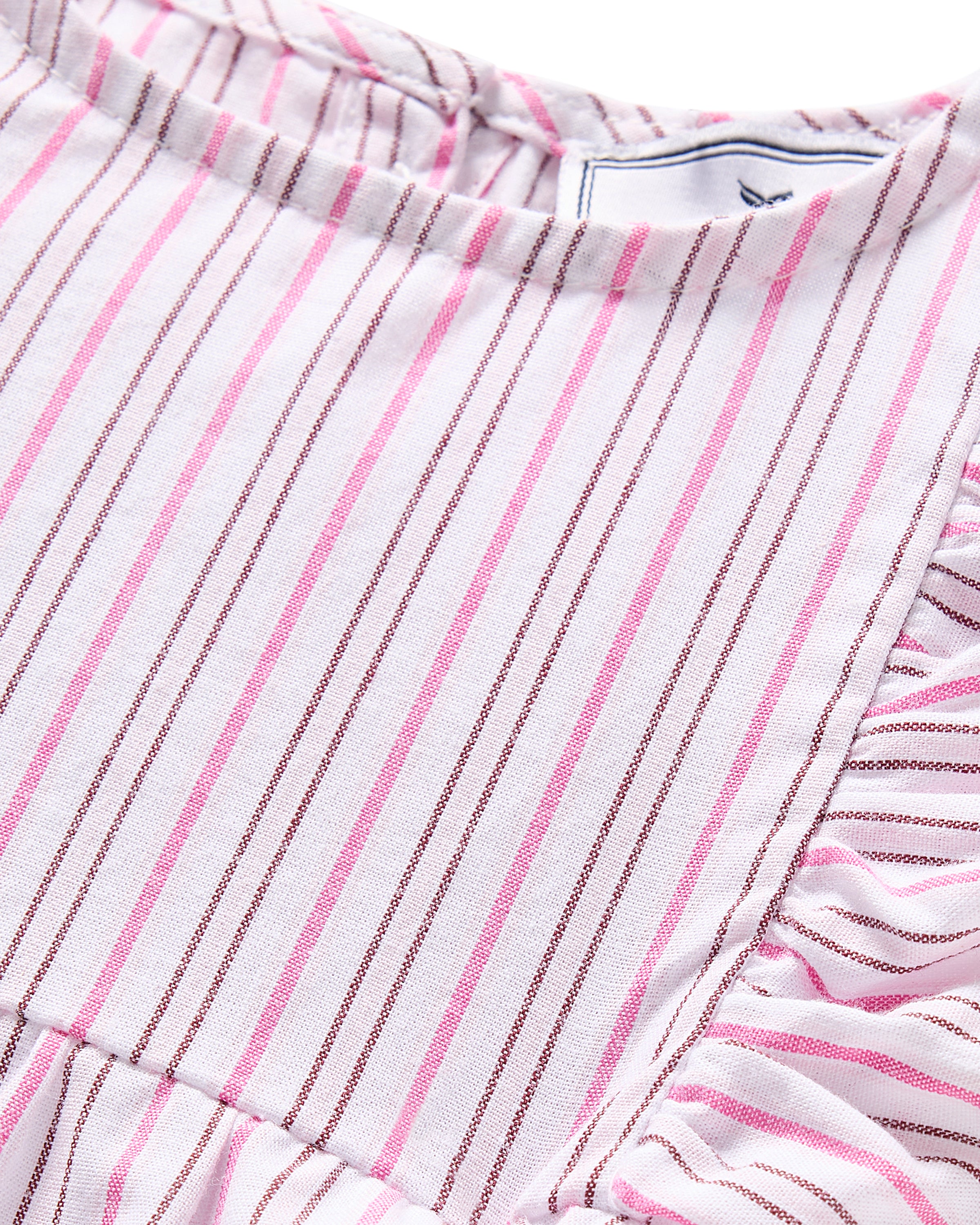 Close-up of Petite Plumes Babys Twill Ruffled Romper in Blush Boulevard, highlighting its vertical pink and brown stripes. The material has ruffled sides that add texture and dimension, ideal for a leisurely stroll.