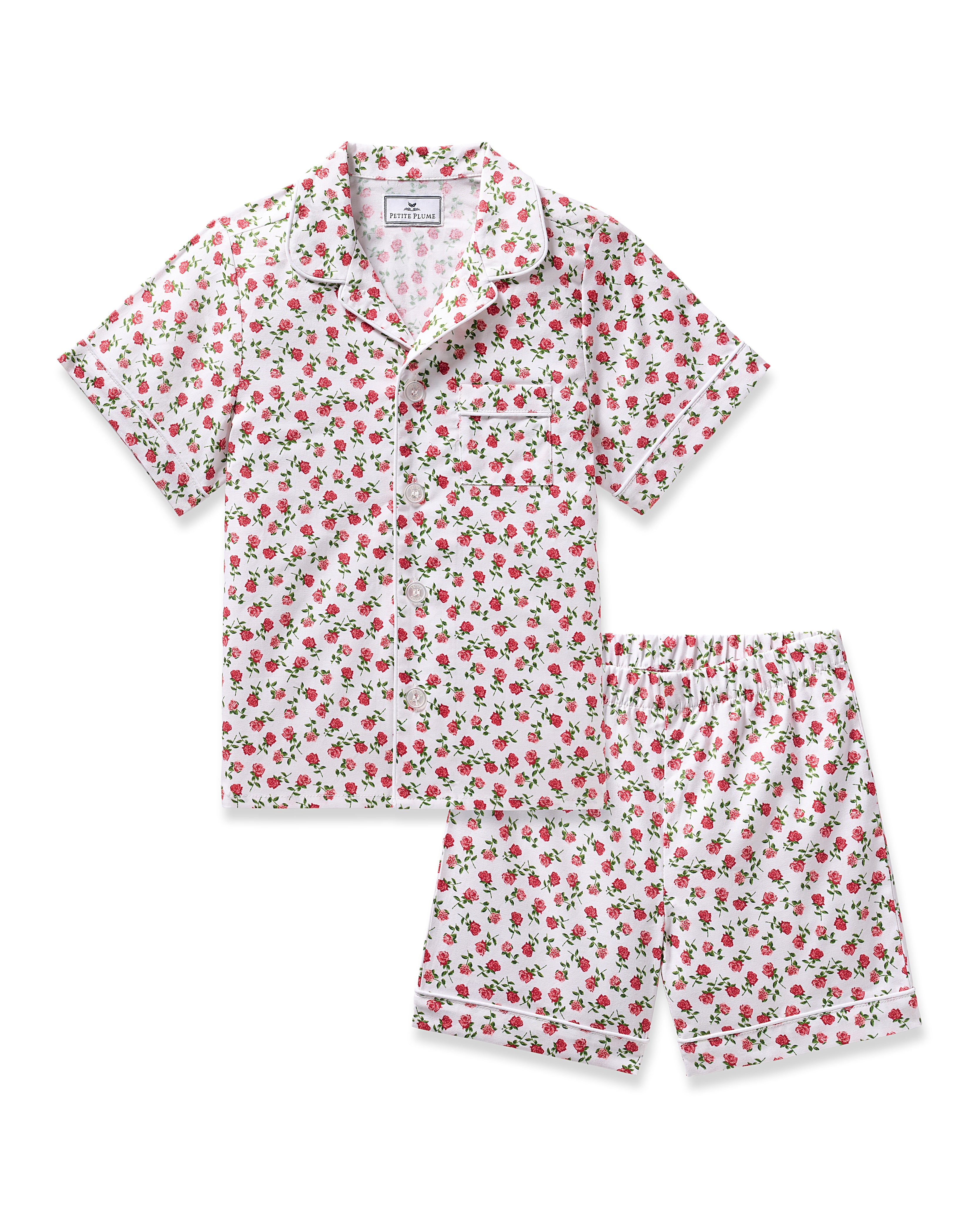 Experience luxury with Petite Plumes Kids Twill Short Set in Petite Petals. This short-sleeve pajama set features a charming floral print on premium cotton, complete with a button-up top, classic collar, chest pocket, elegant piping, and matching shorts for ultimate comfort.