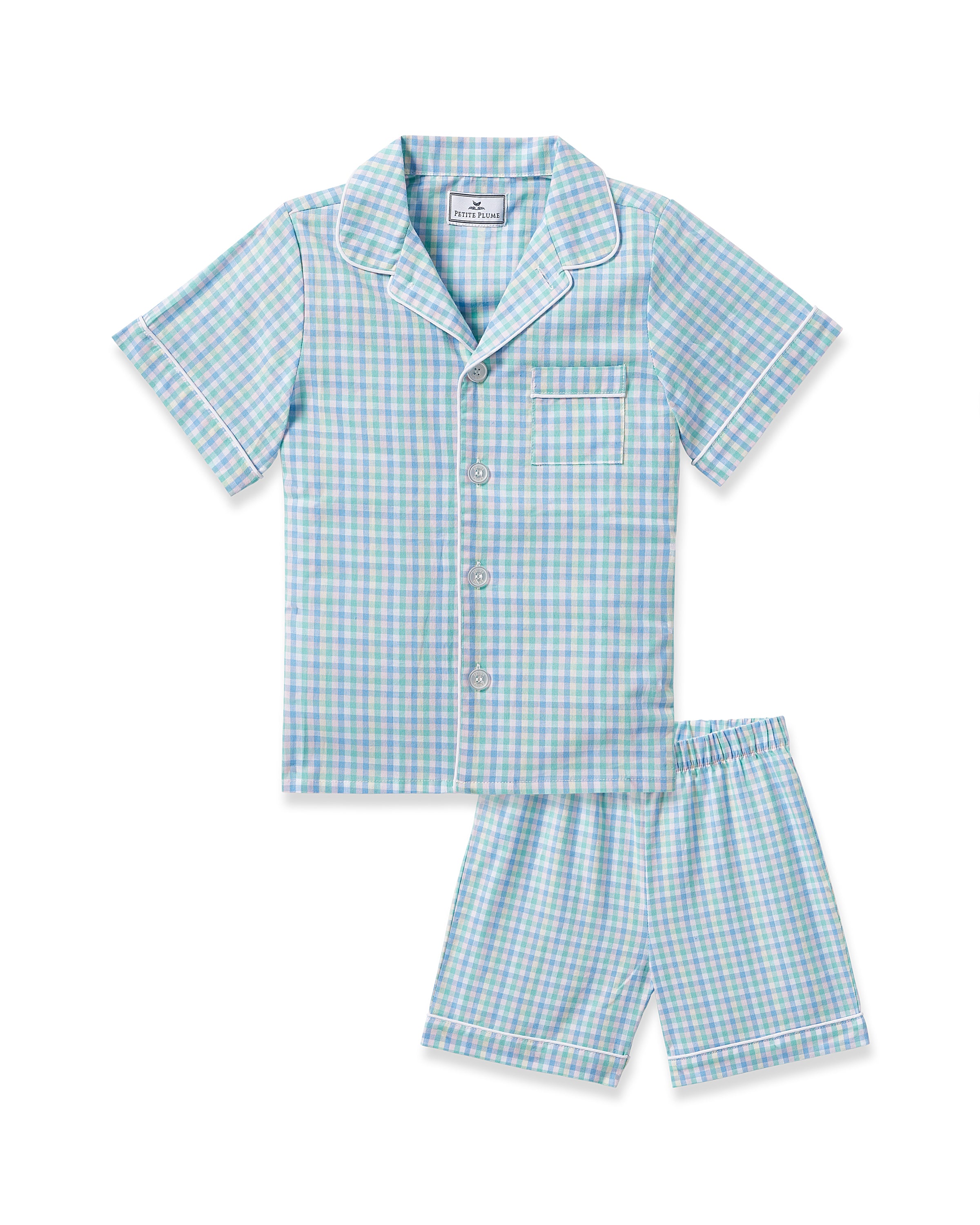 The Kids Twill Short Set in Spring Gingham by Petite Plume highlights a gingham print with a short-sleeved button-up shirt and shorts. It features light blue, white, and green checks with white piping, crafted from flame-retardant cotton for safety.