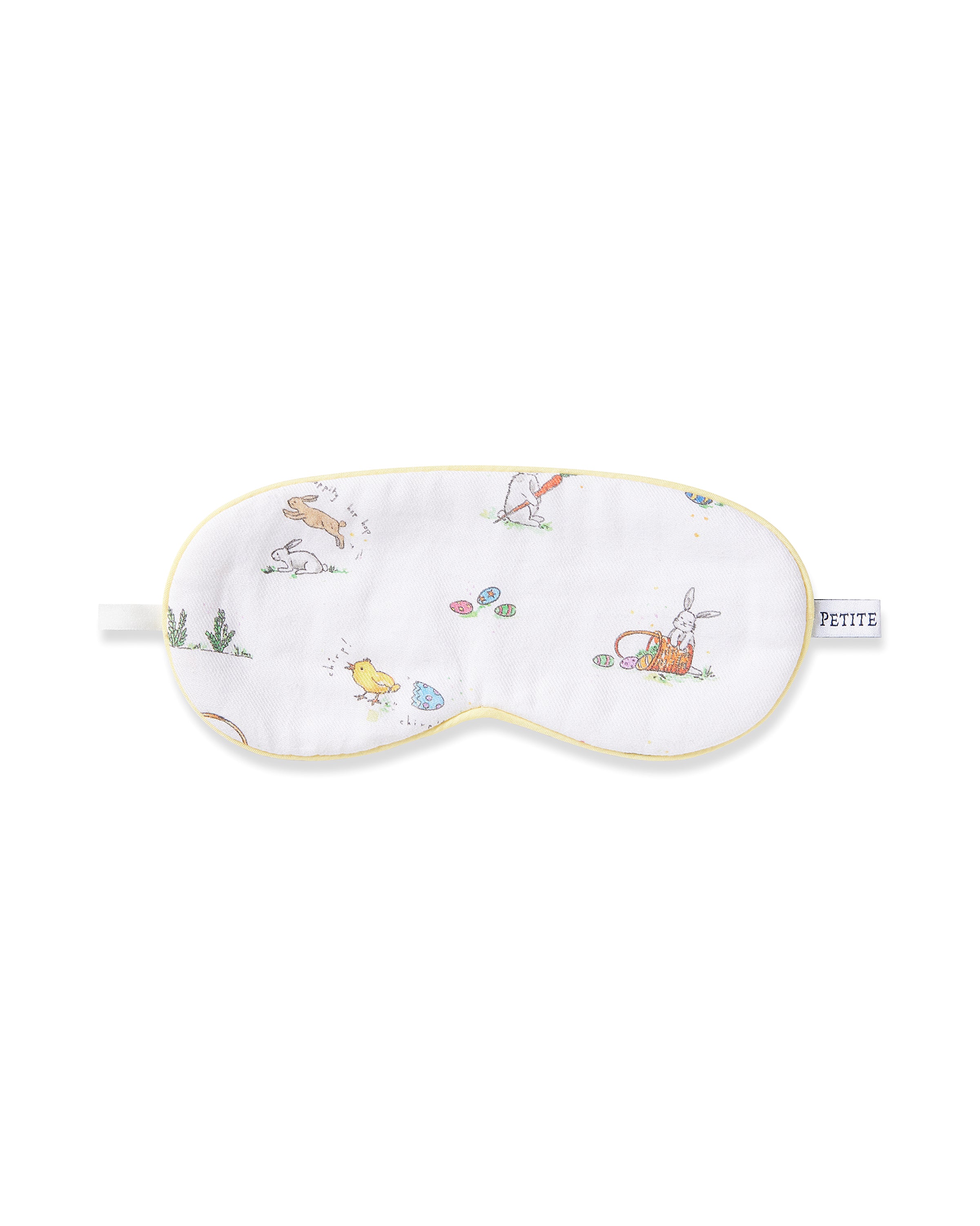 The Kids Twill Sleep Mask in Easter Frolic by Petite Plume, with its soft white fabric and yellow trim, showcases whimsical illustrations of rabbits, chicks, and Easter eggs. It includes a small monogrammed tag on the side, making it an ideal Easter gift.