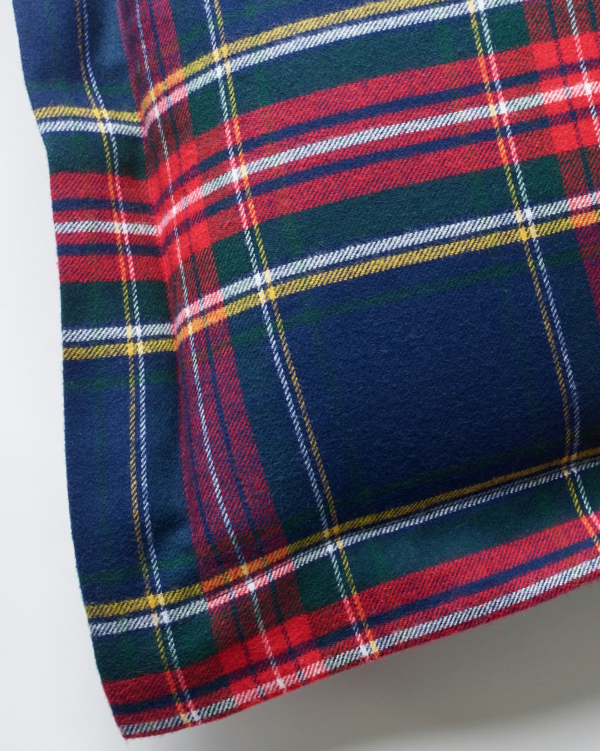 Close-up of Petite Plumes Flannel Euro Sham in Windsor Tartan, showcasing a classic tartan design with red, blue, green, yellow, and white plaid stripes set against a navy blue background in brushed cotton flannel.