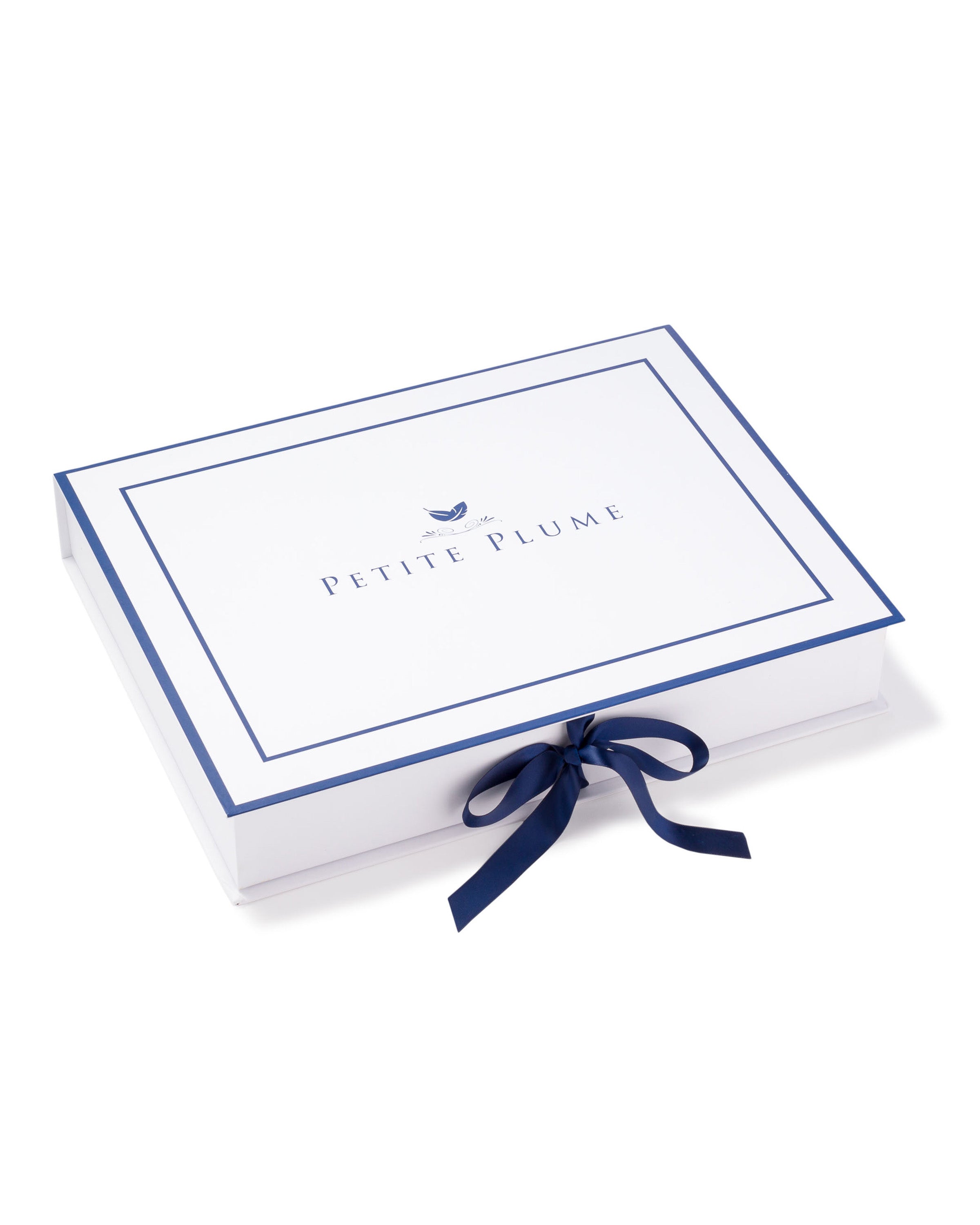 The Essential Maternity Set by Petite Plume features a white rectangular gift box with dark blue edges and a bow, adorned with a small blue bird graphic and Petite Plume text on the lid, making it ideal for any pregnancy journey.