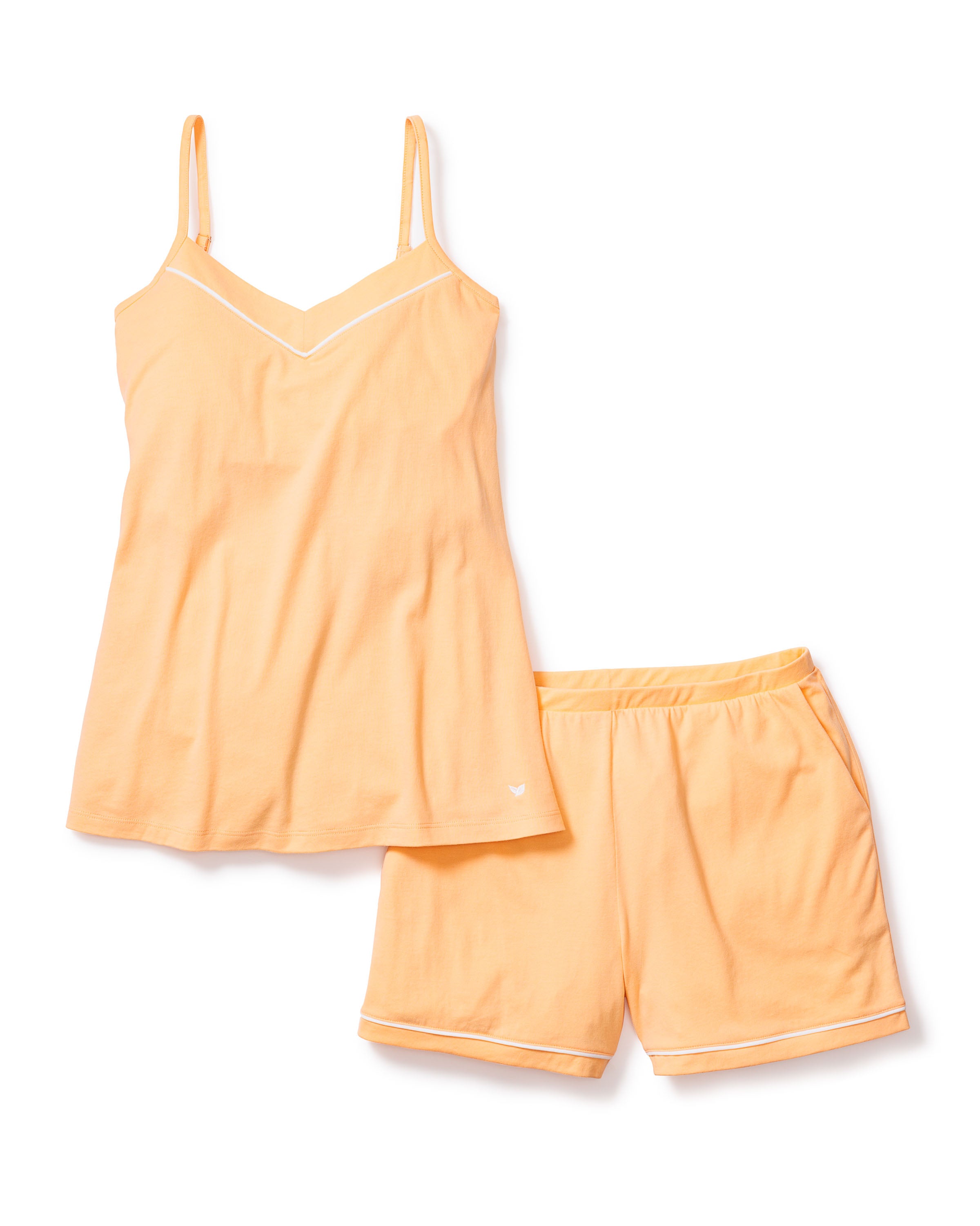 The Womens Pima Sylvie Cami Short Set in Peach by Petite Plume features a buttery spaghetti strap top with a subtle V-neck and matching shorts. Made from light orange Pima cotton with white trim accents, the shorts have an elastic waistband for added comfort.