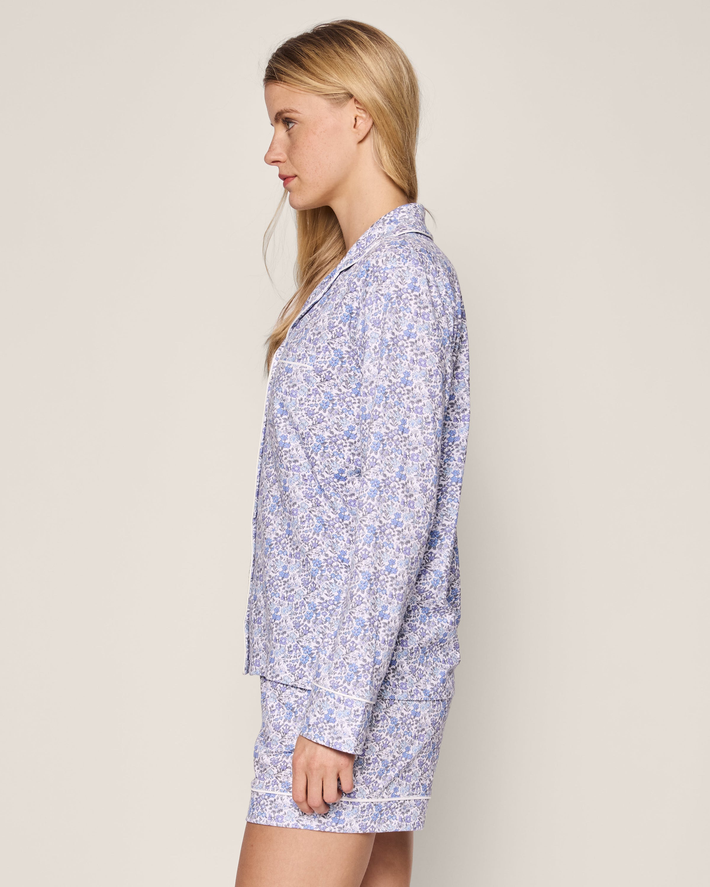 A side view shows a person with long blonde hair wearing Petite Plumes Womens Pima Long Sleeve Short Set in Fleur dAzur, featuring a vintage-inspired blue and white floral print.