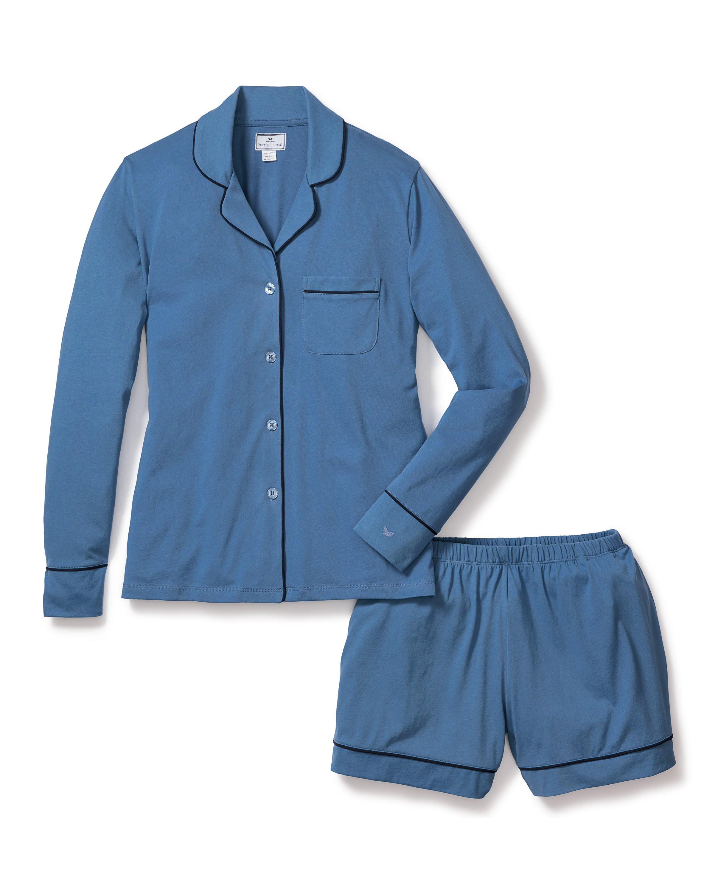 The Womens Pima Long Sleeve Short Set in Mystique Blue by Petite Plume is a serene pajama set made from soft Pima cotton, featuring a button-down top with collar, chest pocket, and dark piping. The elastic-waistband shorts feature matching piping, all showcased on a white background.