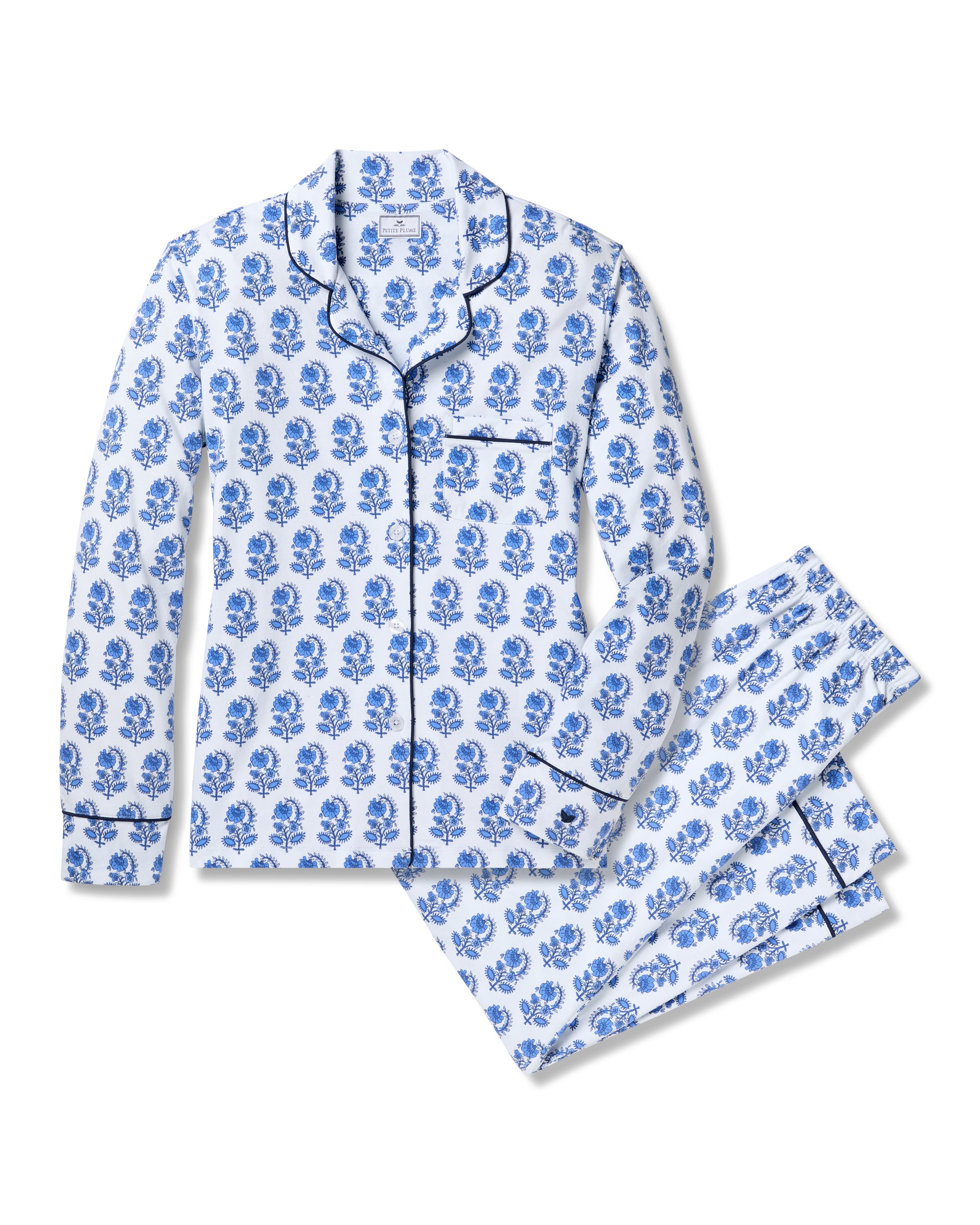 The Womens Pima Pajama Set in Bristol Bay by Petite Plume offers luxury sleepwear with a blue floral pattern on white Peruvian Pima cotton. It features a long-sleeve button-up top with a chest pocket and pants, each adorned with dark piping for an elegant finish.