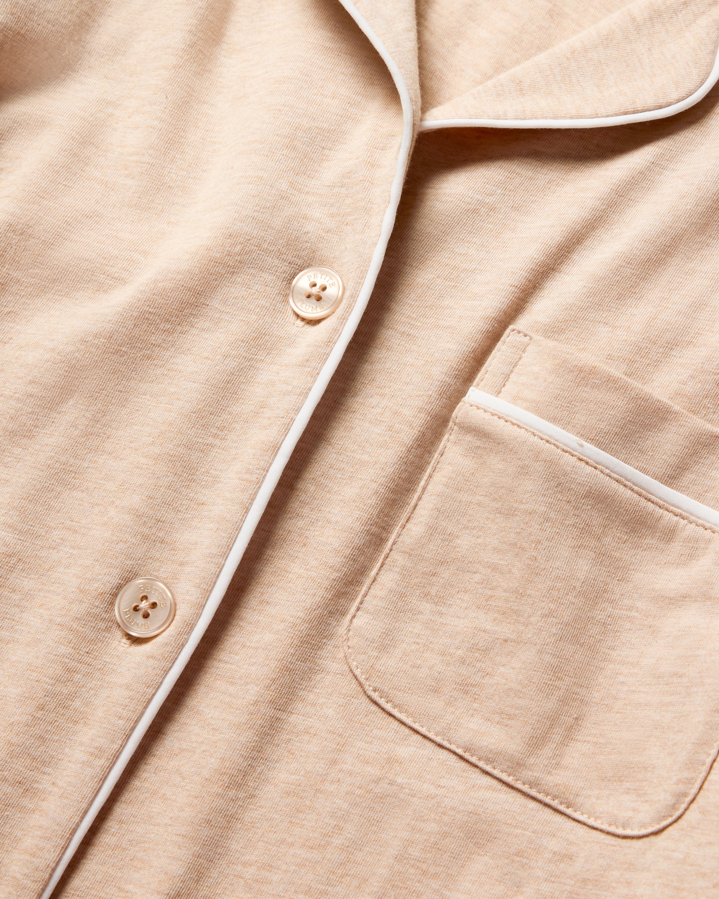 Close-up of the Womens Pima Pajama Set in Camel by Petite Plume, crafted from soft Peruvian Pima cotton with white trim. It features a front pocket and buttons, epitomizing luxury sleepwear.