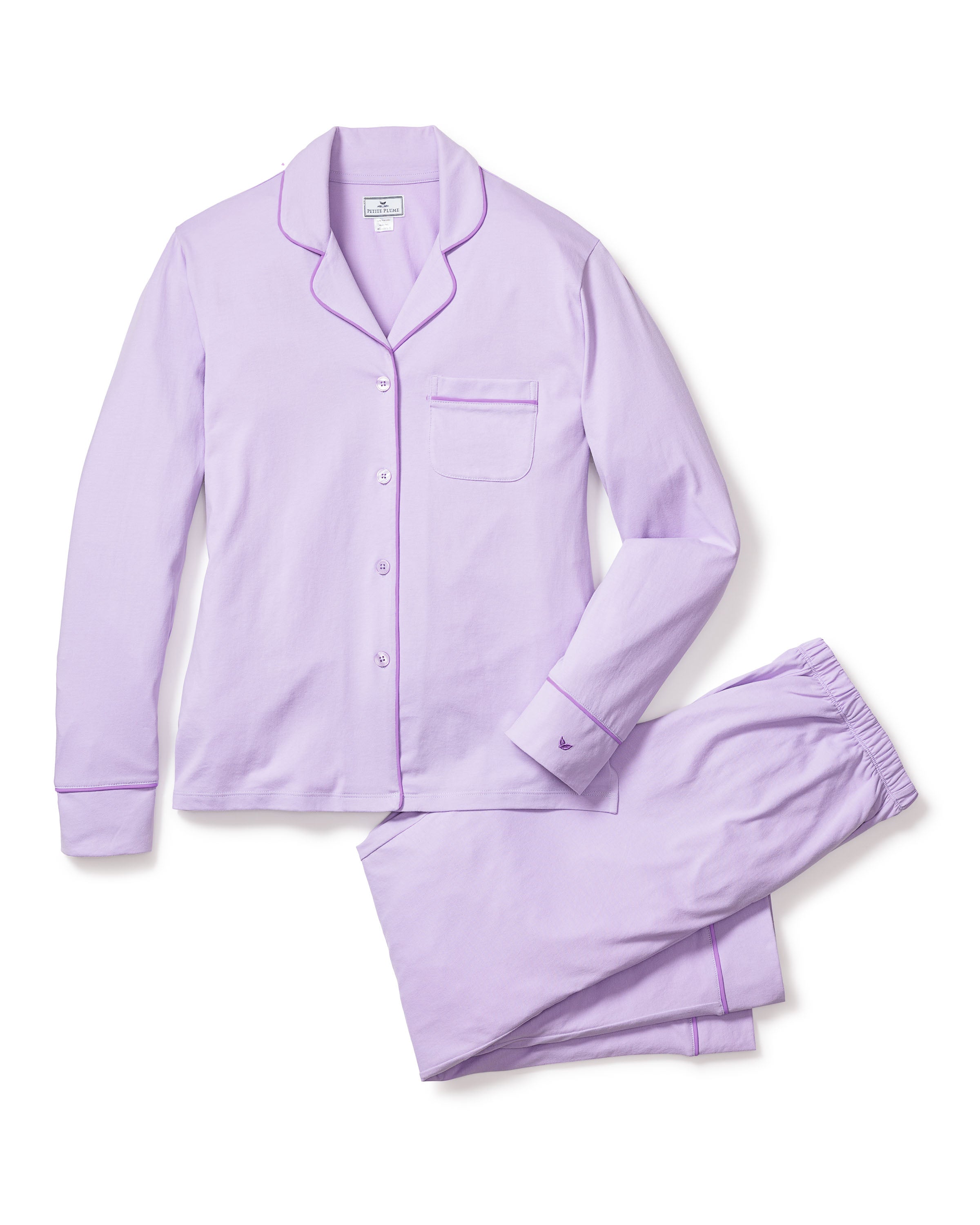 The Womens Pima Pajama Set in Lavender by Petite Plume includes a button-up top with a chest pocket and elegant piping on the collar and sleeve cuffs. Made from soft Peruvian Pima cotton, the pants feature an elastic waistband and matching hem piping for ultimate comfort.