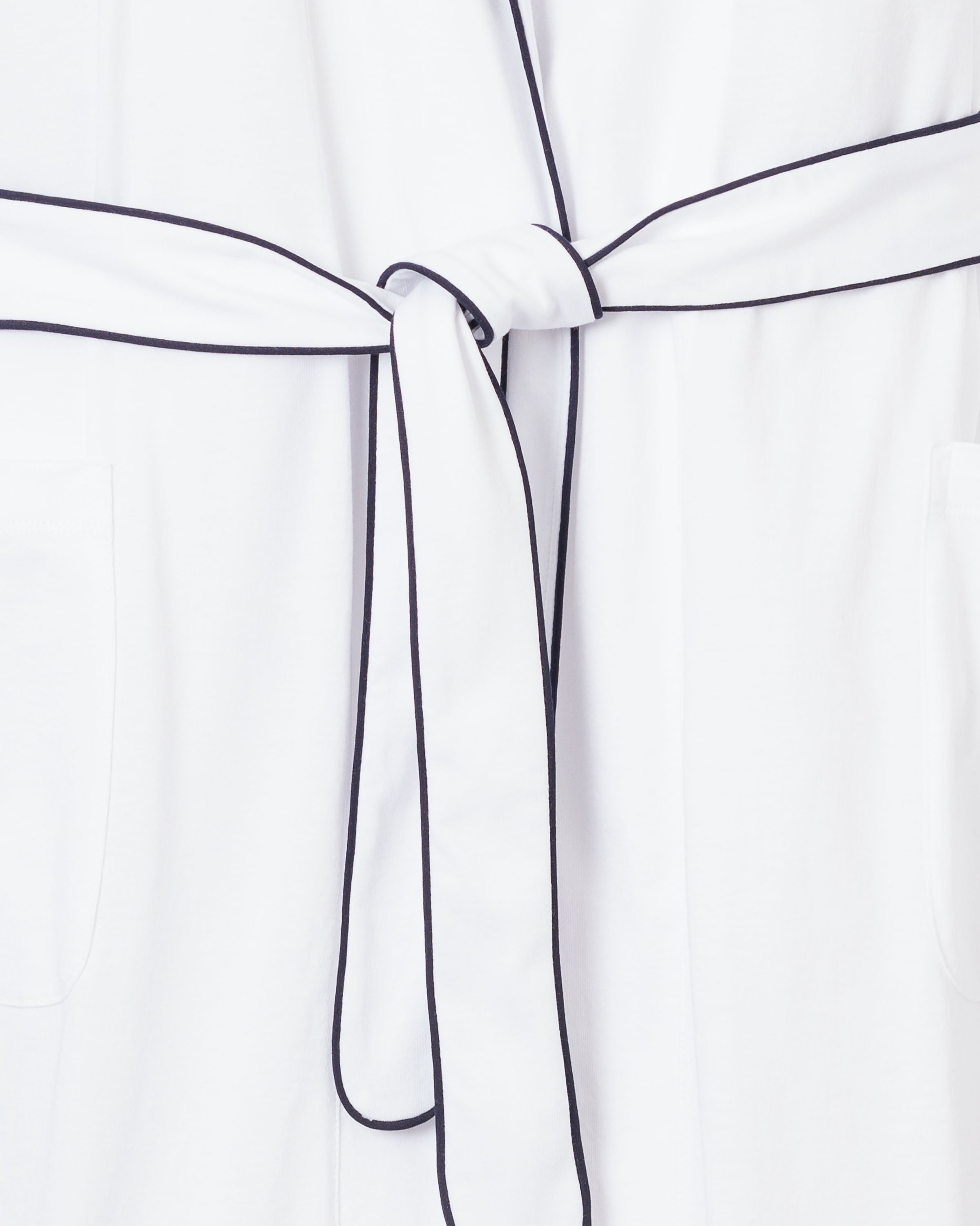 Close-up of the Petite Plume Womens Pima Robe in white with navy piping, tied at the waist. The soft Peruvian Pima cotton robe features front pockets, with a focus on the belt knot and minimalistic design.