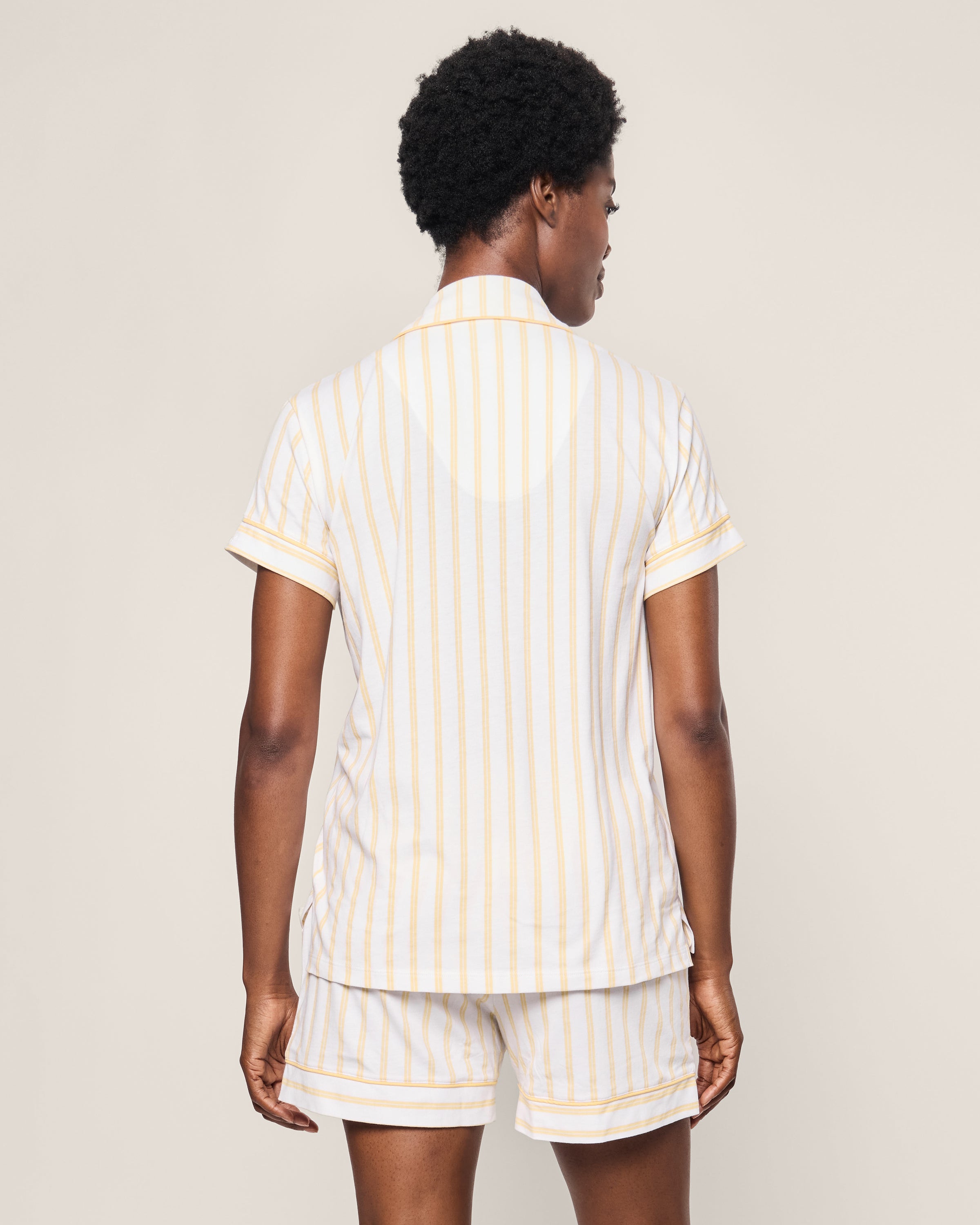 Rear view of a person with short curly hair wearing Petite Plumes Womens Pima Short Sleeve Short Set in Sunny Stripe against a plain background.