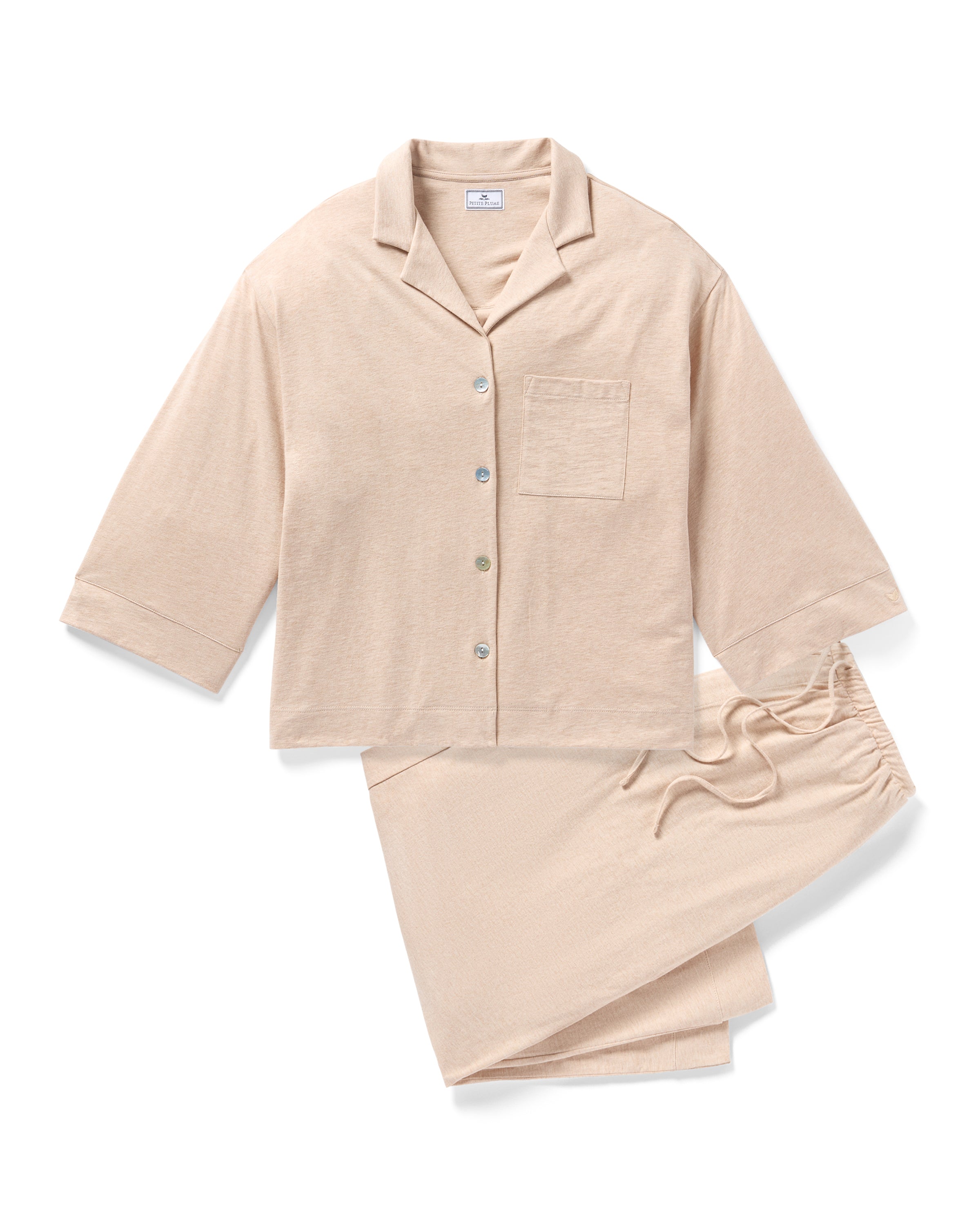 The Olivia Wide Leg Pima Pajama Set in Camel by Petite Plume is crafted from soft Peruvian Pima cotton and includes a button-up shirt with a front pocket and three-quarter sleeves, paired with drawstring pants. Perfect for lounging or sleeping in comfort.