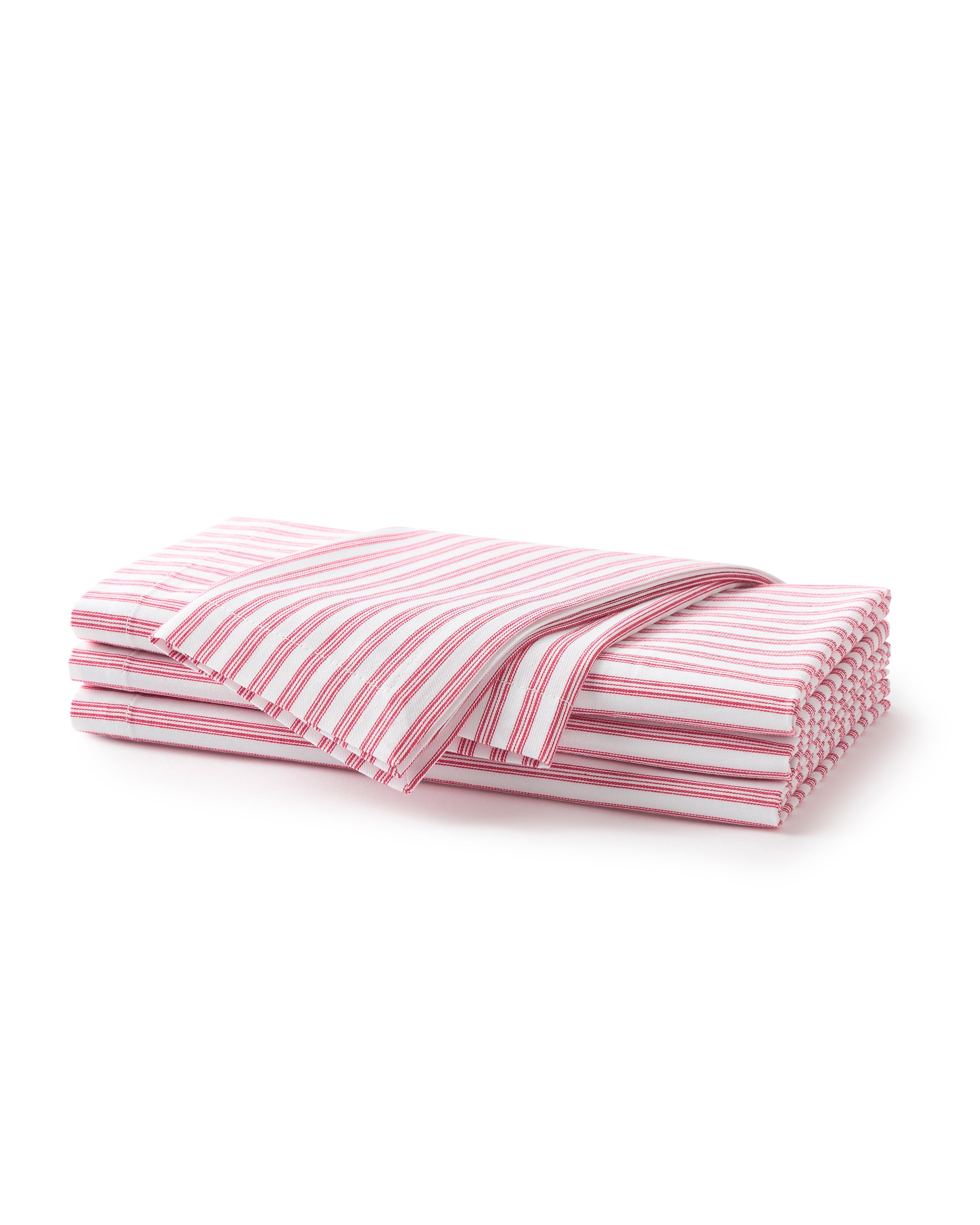 A neatly folded stack of Petite Plumes Signature Twill Table Napkins in Antique Red Ticking features red and white horizontal stripes, with one napkin slightly pulled out on top, ideal for adding charm to any festive tablescape.