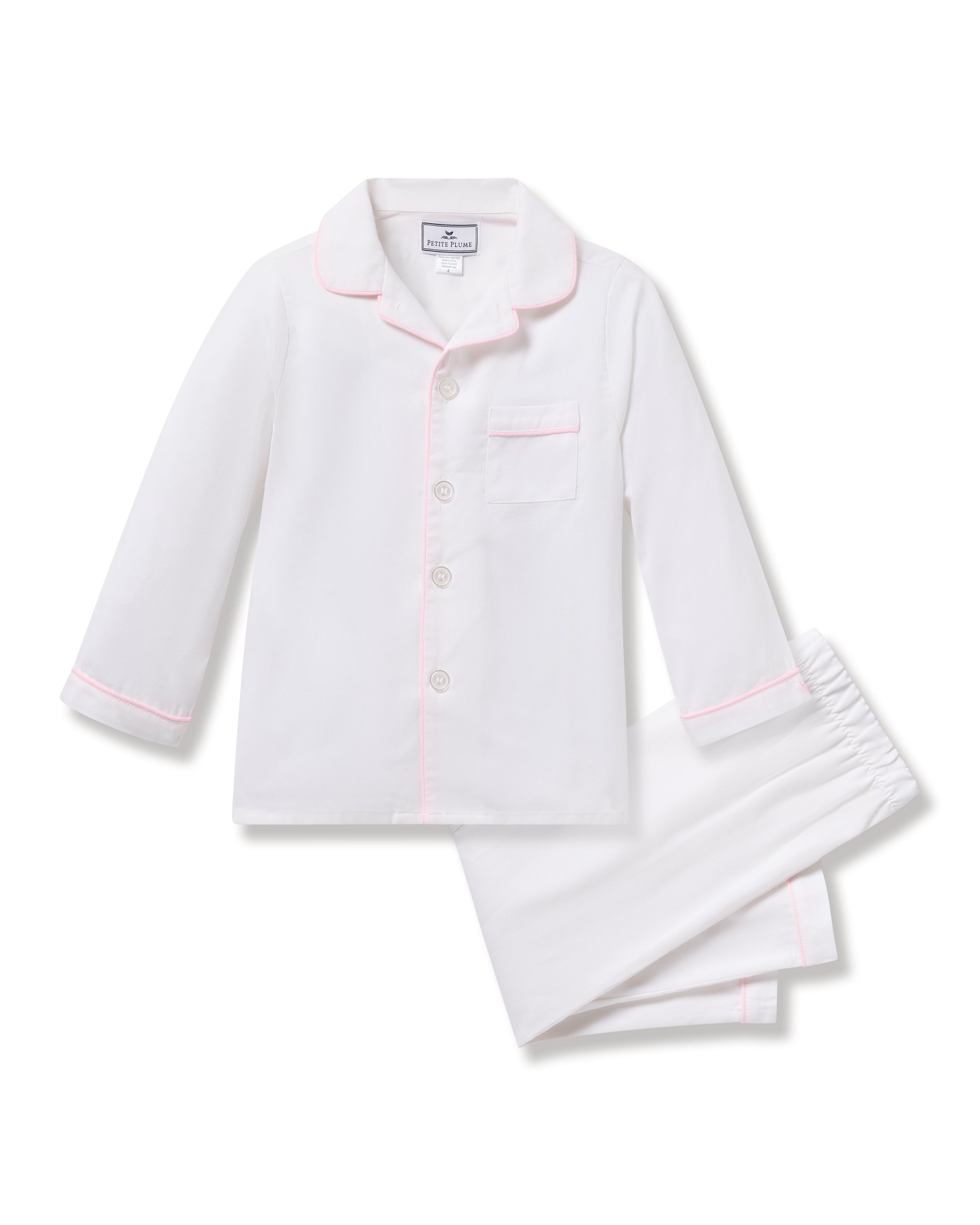 The Petite Plume Kids Twill Pajamas in White with Pink Piping feature a button-up long-sleeve top with pink piping on the collar and cuffs, a front pocket, and matching elastic waist pants. Made from high-quality cotton for luxurious comfort.