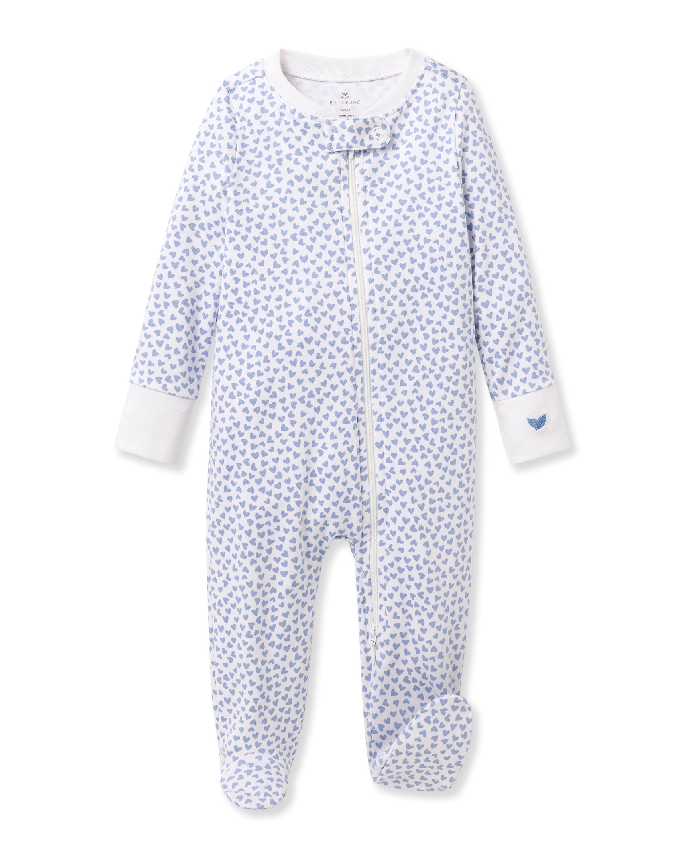 The Babys Pima Romper in Bluehearts by Petite Plume is a light-blue sleeper with small heart patterns on a white background. Made from 100% Pima cotton, it features a front zipper closure, long sleeves, and a single heart on the left cuff for a cozy minimalist design.