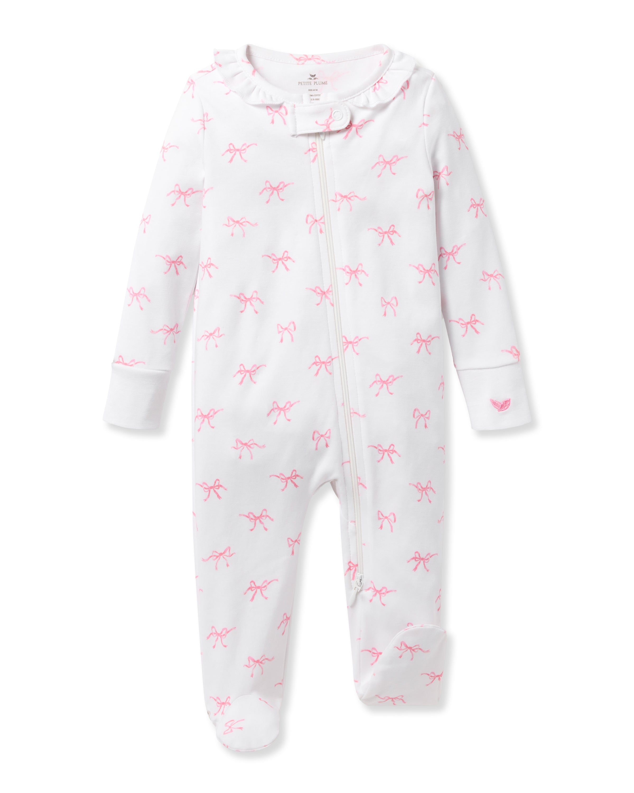 The Petite Plume Babys Pima Ruffle Collar Romper in Blushing Bows is a white, footed, long-sleeve onesie featuring a pink bow pattern and ruffled collar. Made from 100% Pima cotton for comfort, it has a front zipper for easy dressing. Ideal as a Valentines Day romper.