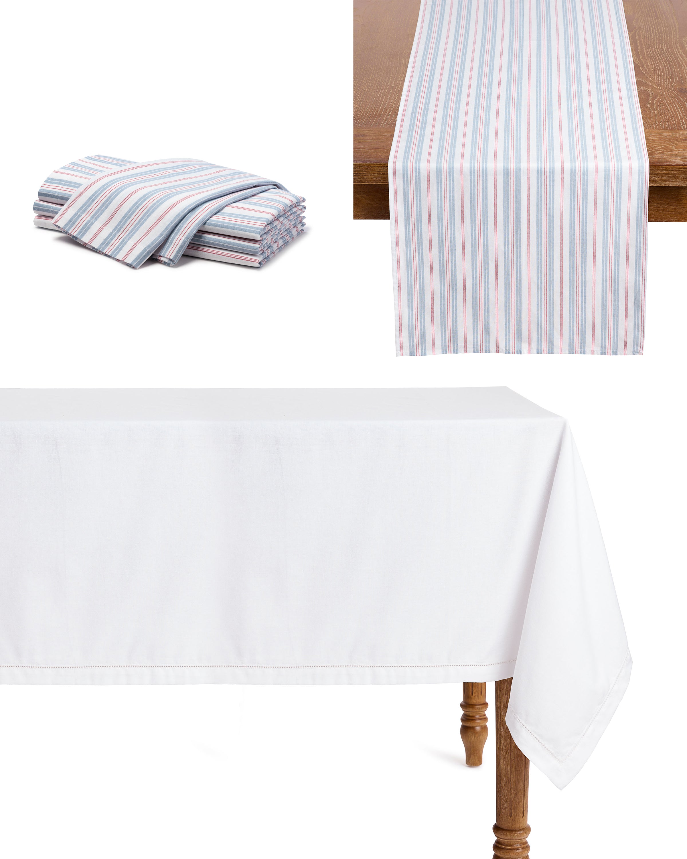 The Signature Twill Table Linen Set in Vintage French Stripe by Petite Plume graces the wooden surface, while a plain white cotton linen drapes elegantly over another, creating a festive tablescape with subtle charm.