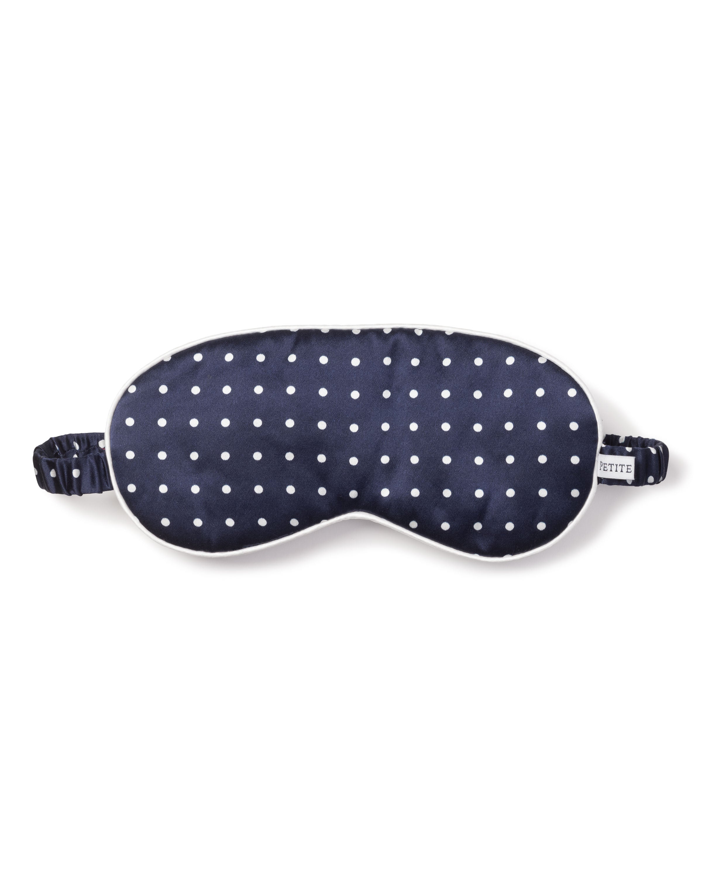 The Petite Plume Adults Silk Sleep Mask in Navy Polka Dot is made from pure silk and includes a gathered elastic strap for a perfect fit.