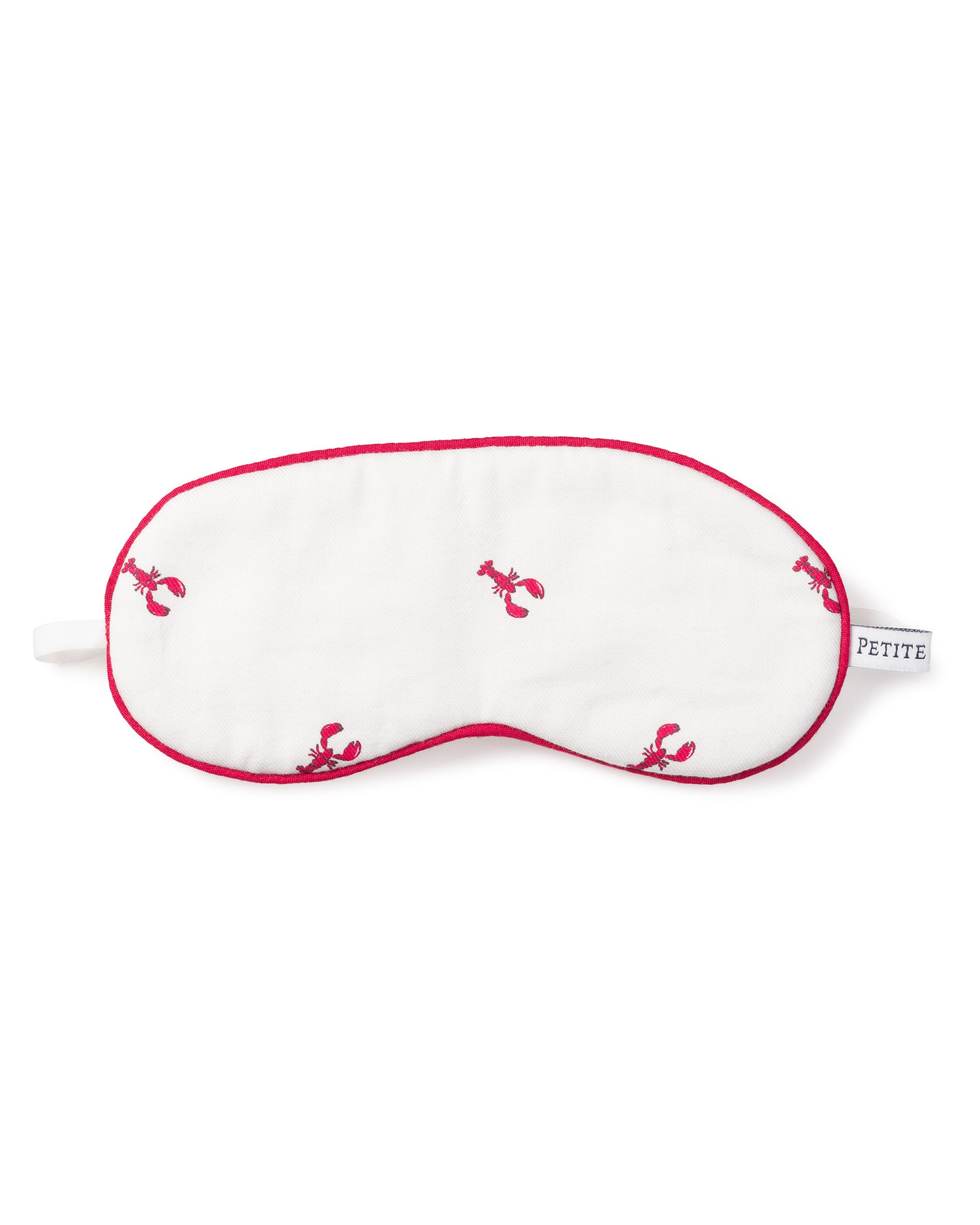 The Kids Sleep Mask in Brixham Lobsters by Petite Plume is a luxurious white mask with red lobster prints and red edges, featuring a PETITE tag on the right side. Matching eye masks are available for those who enjoy coordinated rest.