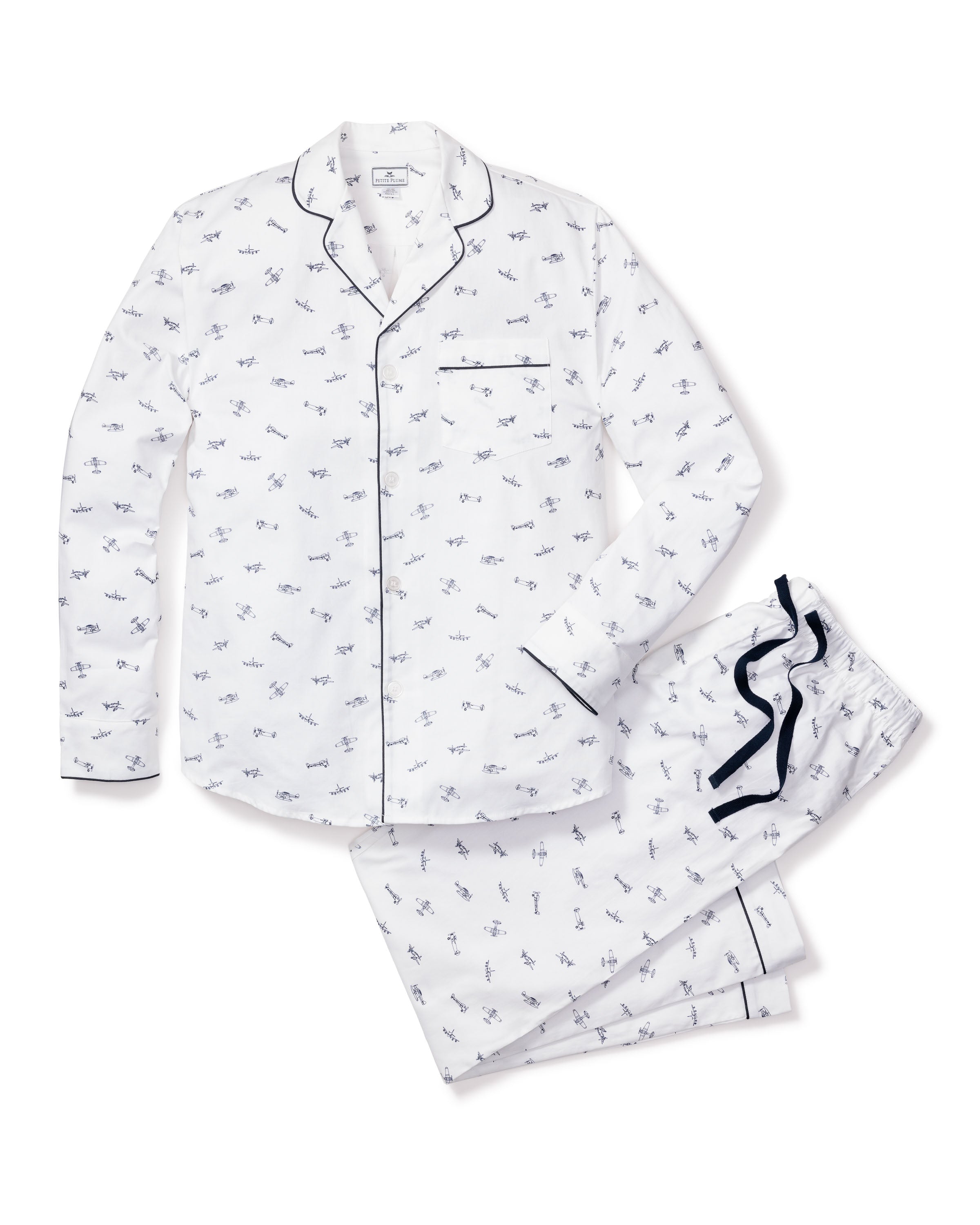 The Petite Plume Mens Twill Pajama Set in Par Avion is crafted from premium cotton and features a subtle dinosaur pattern. The shirt is adorned with black piping on the collar and pocket, while the pants have a comfy drawstring waist with black accents.