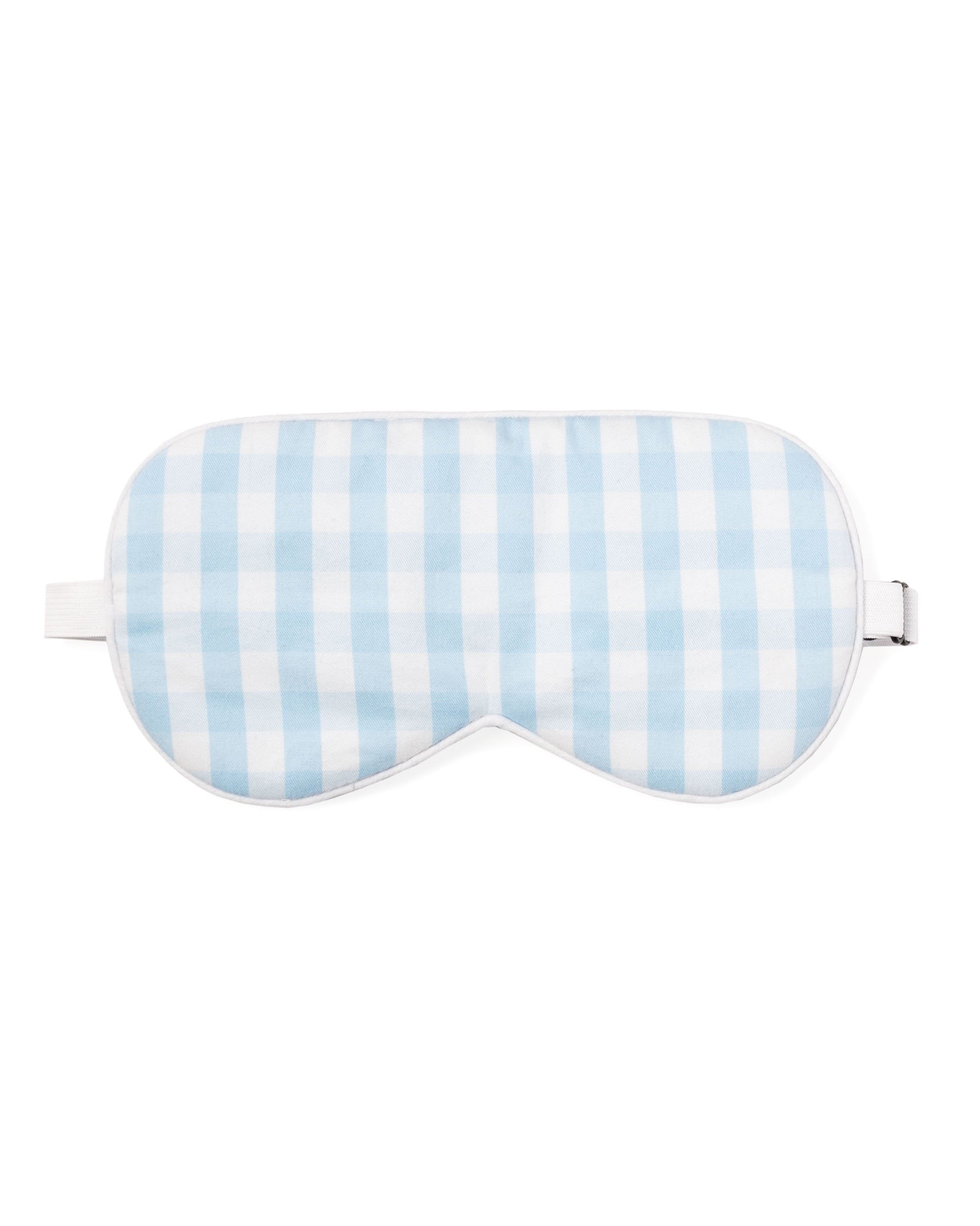 The Petite Plume Adults Twill Sleep Mask in Light Blue Gingham features an elastic strap, offering a touch of luxury for those who appreciate indulgence.