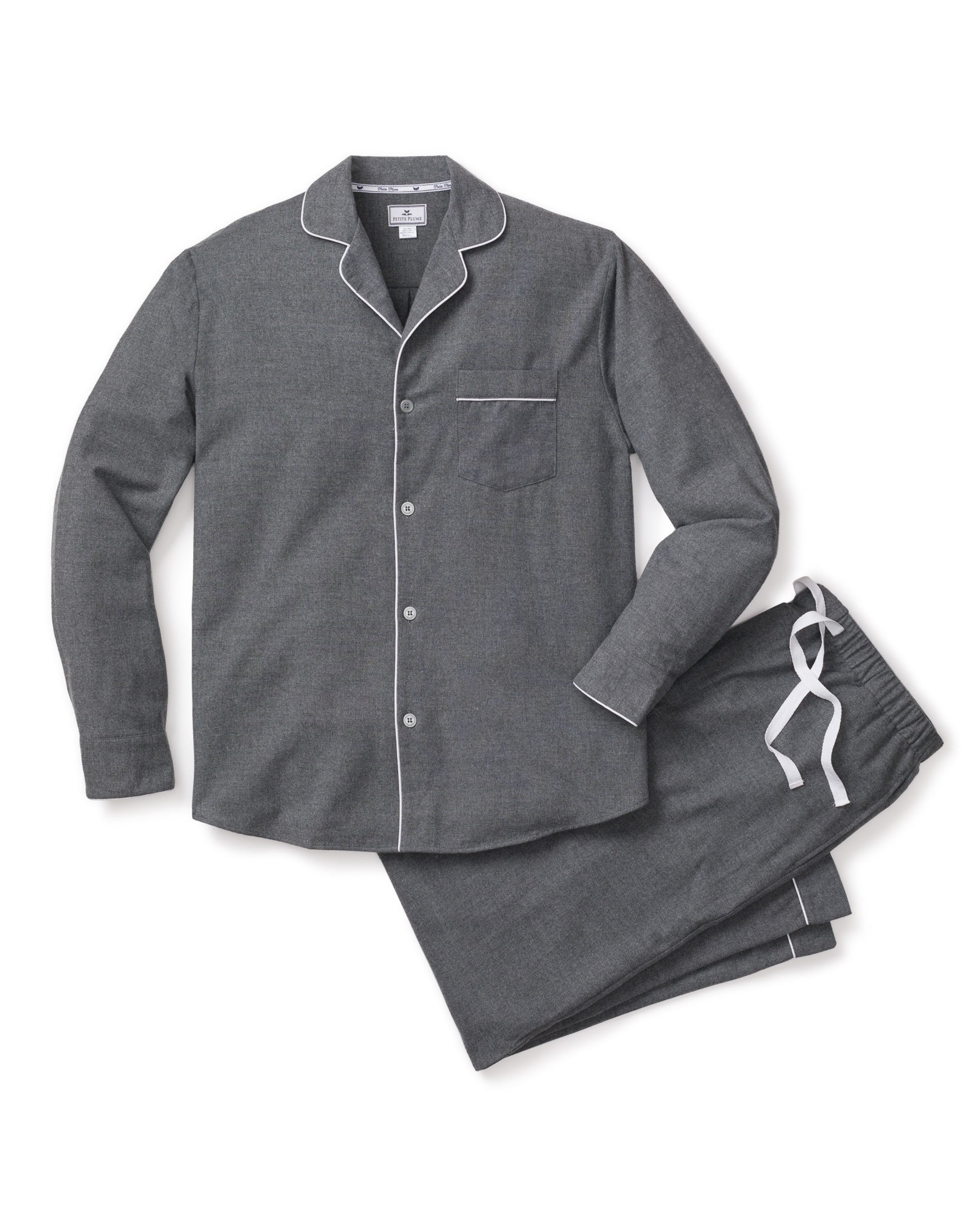 The Petite Plume Mens Flannel Pajama Set in Grey features a stylish, moisture-wicking weave. The gray top includes white piping, long sleeves, a front pocket, and buttons down the front. The comfy bottoms have an elastic waistband and a contrasting white drawstring for an ideal fit.