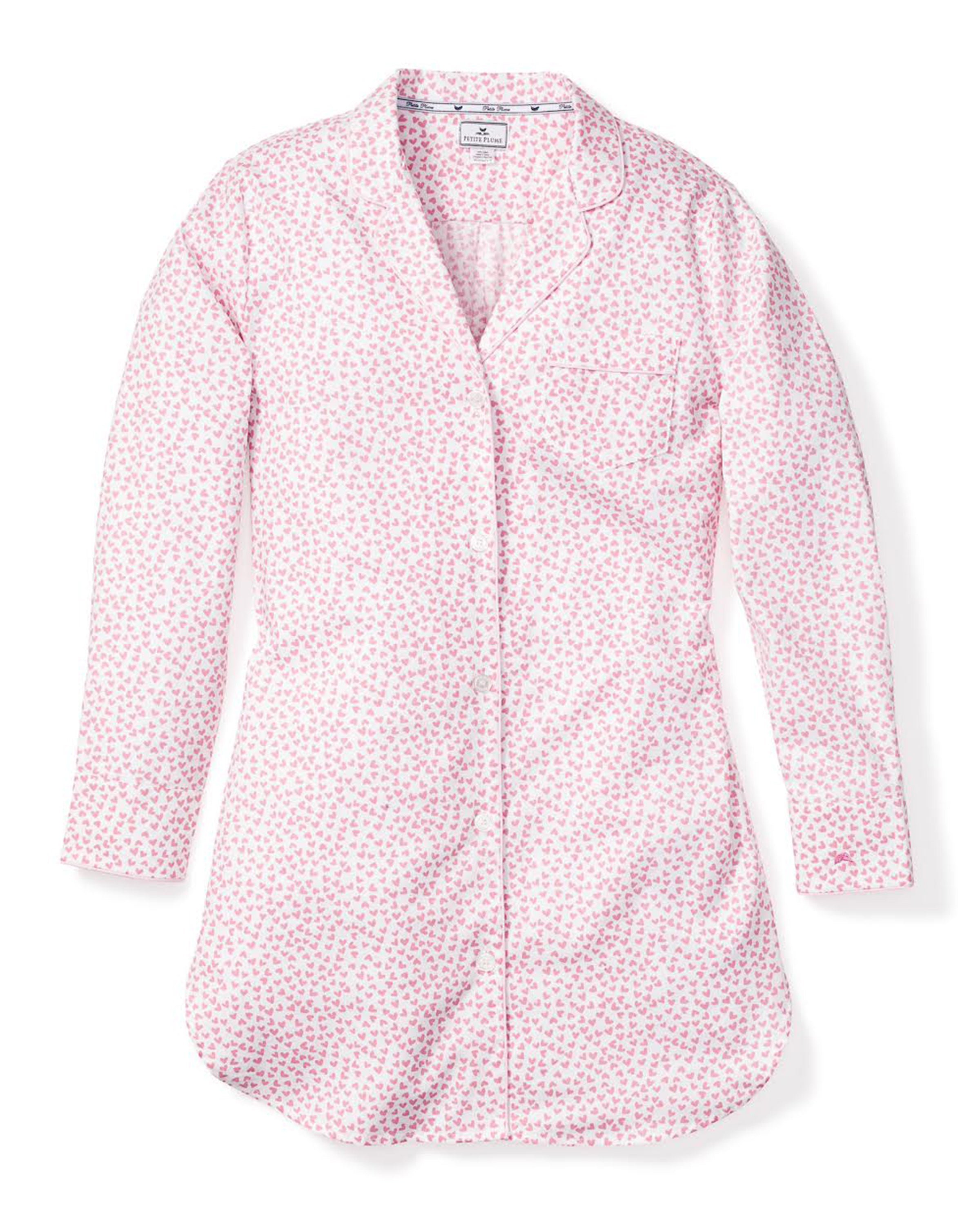 The Womens Twill Nightshirt in Sweethearts by Petite Plume is a luxurious, long-sleeved sleepwear piece featuring a soft pink floral pattern on a white background. Crafted from premium cotton, it has a notched collar and small chest pocket, elegantly laid flat on a plain white backdrop.