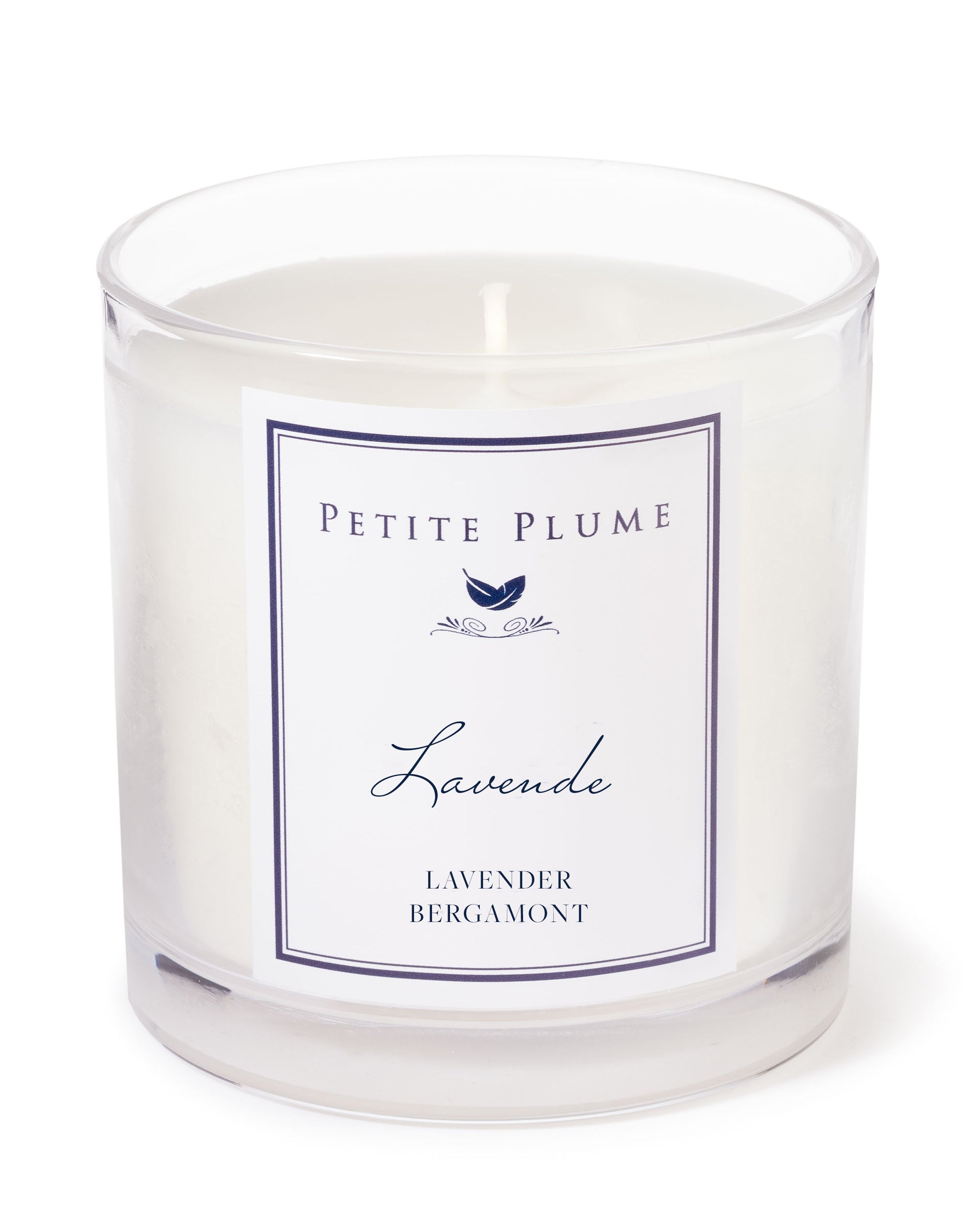 The Petite Plume Lavande Candle from the Candle Collection features a clear glass with white wax, labeled Lavender & Bergamot with a simple bird logo. Its design is minimalistic and elegant.