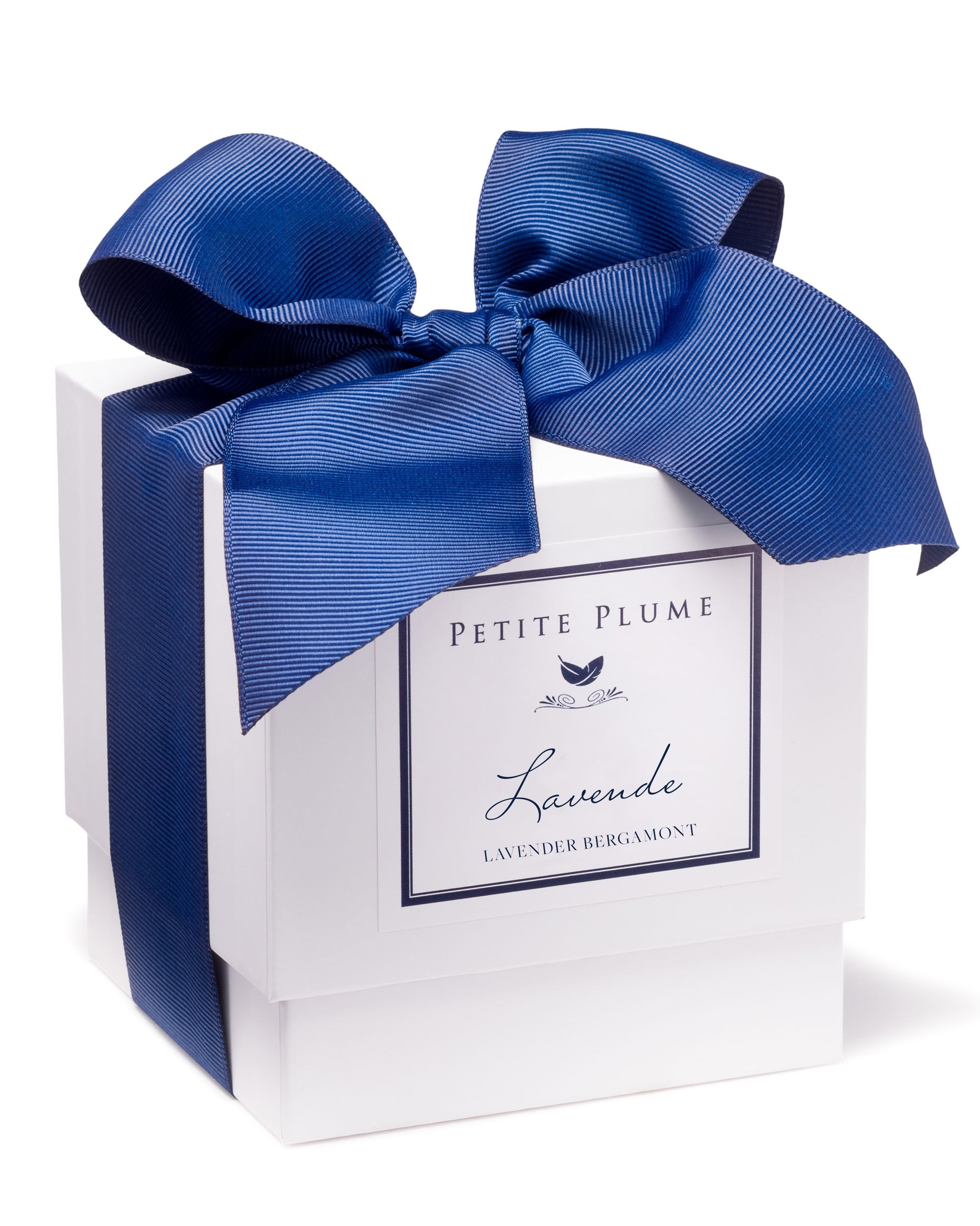 The elegant white gift box, topped with a large blue bow, features the Petite Plume Lavande Candle label. The decorative text and design hint at the calming scents of Petite Plumes Lavender & Bergamot Candle Collection.