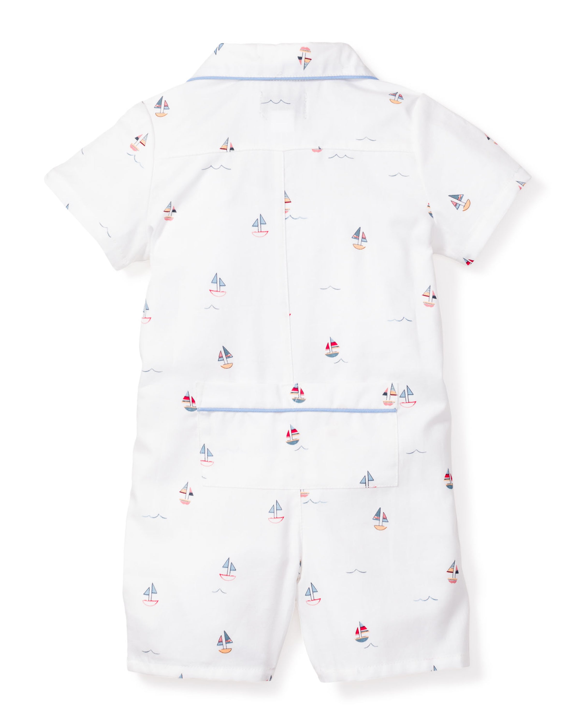 The Babys Twill Summer Romper in Bateau by Petite Plume showcases a back view of white fabric with colorful sailboat prints, featuring short sleeves, a blue-trimmed collar, and a back pocket. Made from flame-retardant material for safety and comfort throughout the night.